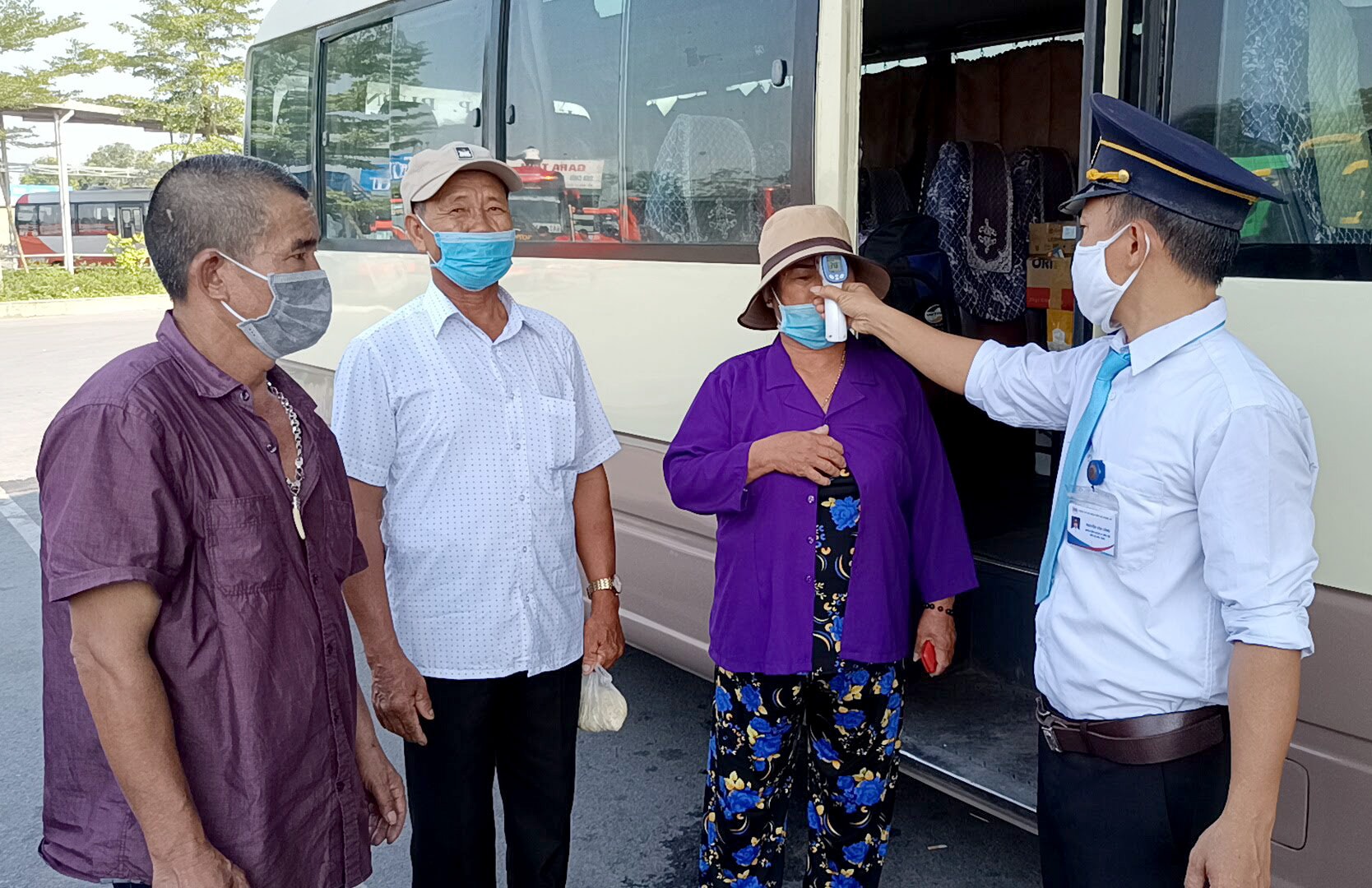 Hành khách được kiểm tra thân nhiệt và yêu cầu đeo khẩu trang trước khi lên xe tại Bến xe Bắc Vinh