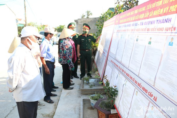 Cán bộ, chiến sỹ Ban CHQS huyện Quỳnh Lưu hướng dẫn bà con nhân dân xã Quỳnh Thanh theo dõi danh sách các đại biểu được bầu trên địa bàn. Ảnh: Hoàng Trung