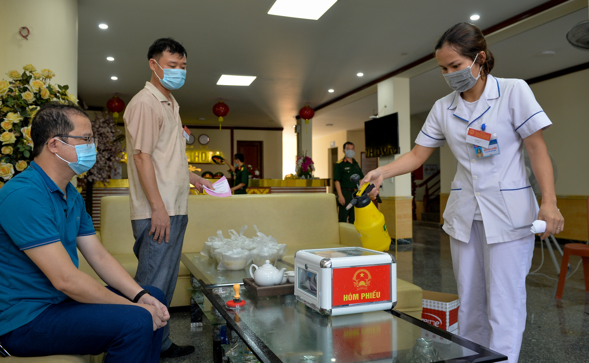 7 giờ sáng ngày 23/5, công tác bầu cử tại Khu cách ly y tế tập trung Khách sạn Sông Hoàng được hoàn tất. Cán bộ y tế thực hiện phun hóa chất tiêu độc, khử trùng hòm phiếu. Ảnh: Thành Cường