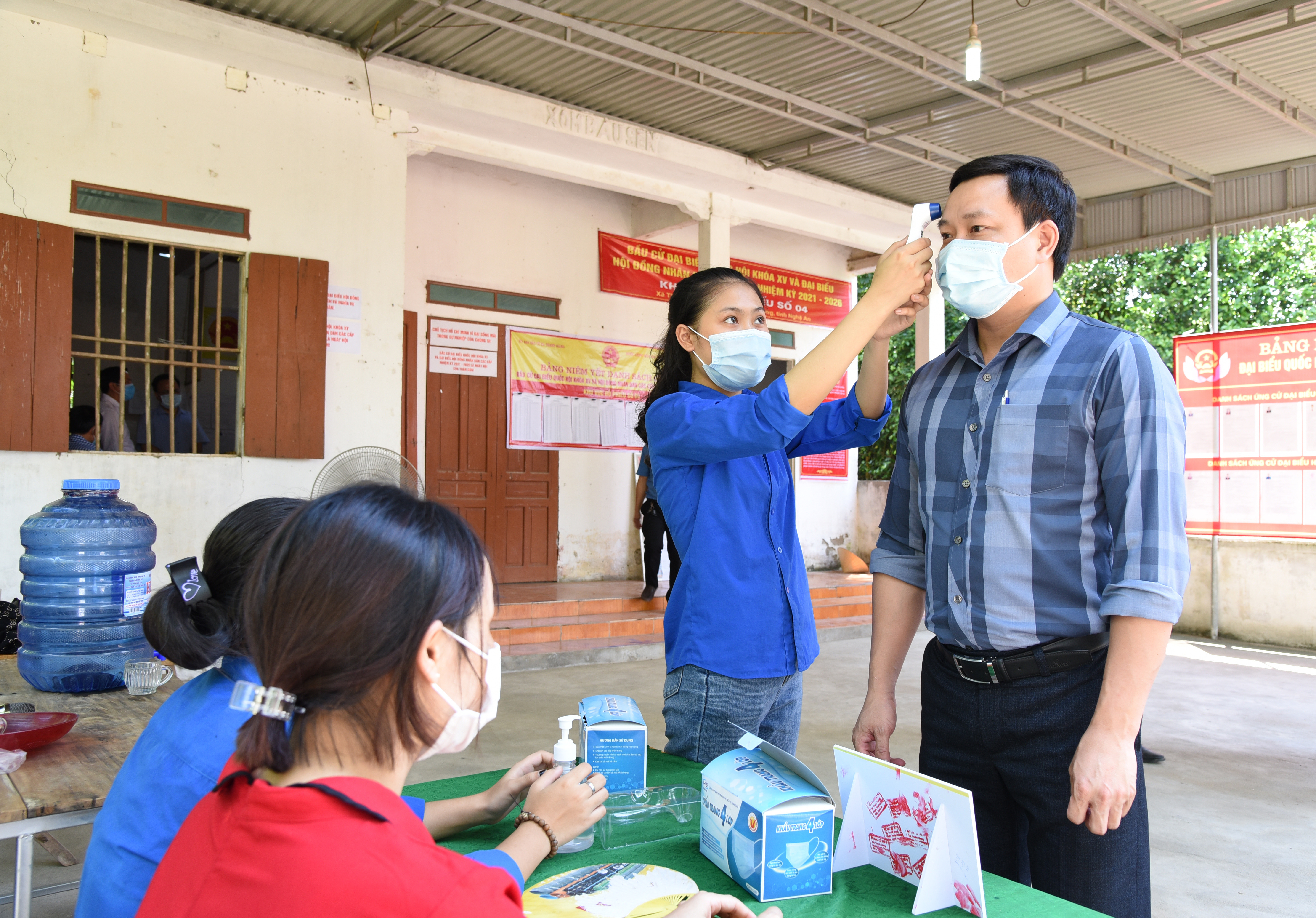 Đoàn viên thanh niên xã Thanh Giang tích cực tham gia phục vụ cuộc bầu cử, trực tại bàn tiếp đón, đo thân nhiệt, hướng dẫn cử tri sát khuẩn tay. Ảnh: TG