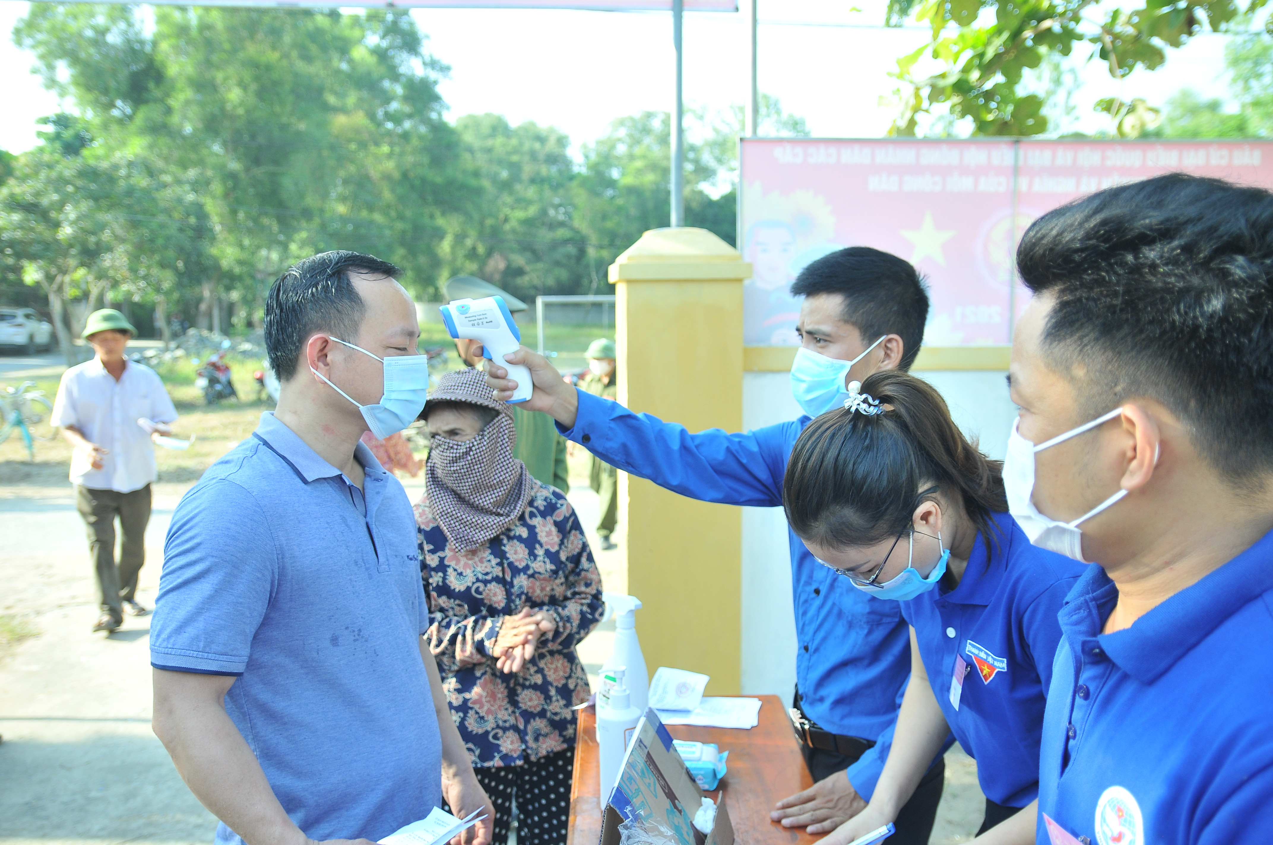 Người dân được đo kiểm tra thân nhiệt trước khi vào điểm bầu cử tại xã Nghi Phong, Nghi Lộc. Ảnh: Tiến Đông