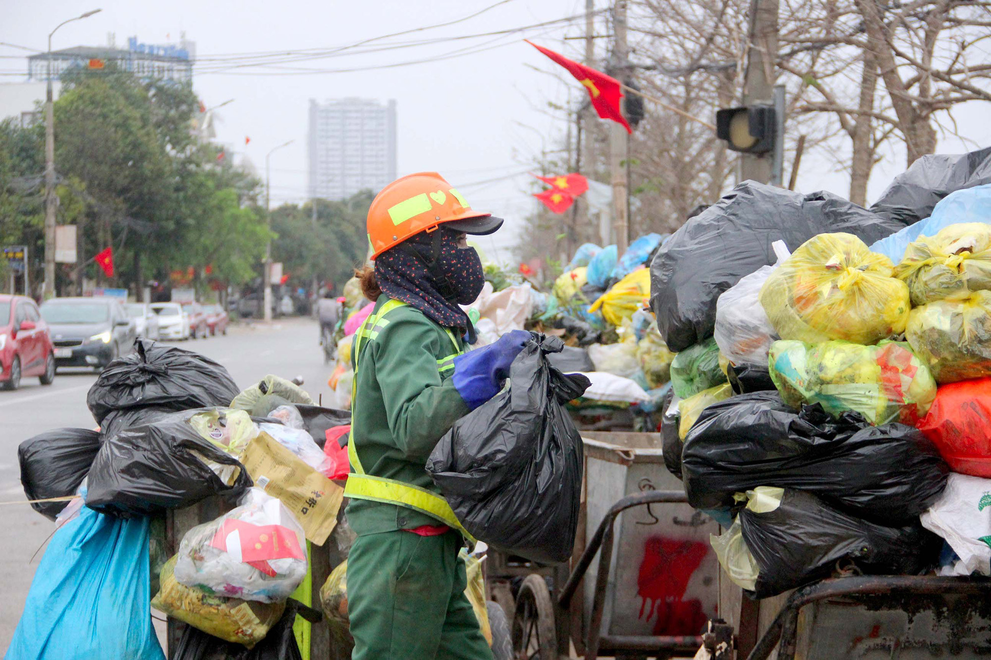 Công nhân vệ sinh môi trường TP Vinh thu gom rác thải sinh hoạt tại đường Nguyễn Sỹ Sách. Ảnh: Quang An