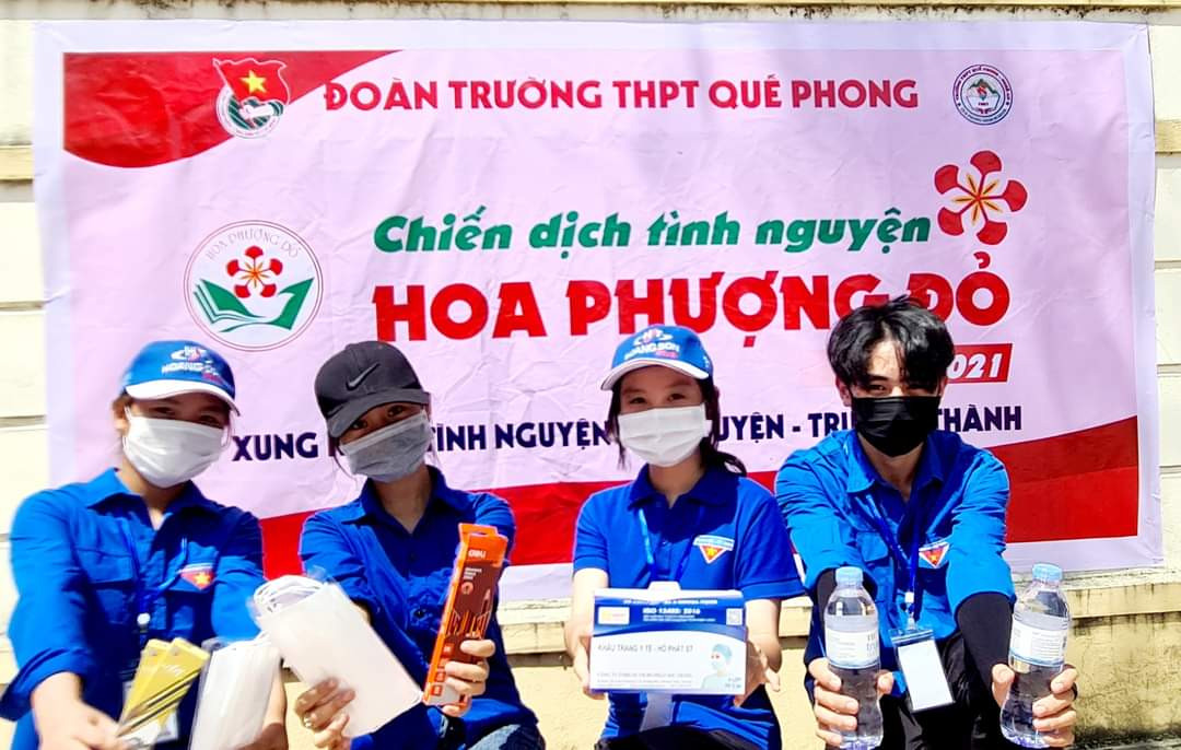 Đội tình nguyện Hoa phượng đỏ của Trường THPT Quế Phong đã kịp thời hỗ trợ thí sinh nước, khẩu trang, quạt mát và nước sát khuẩn. Ảnh: Chiến Thắng.