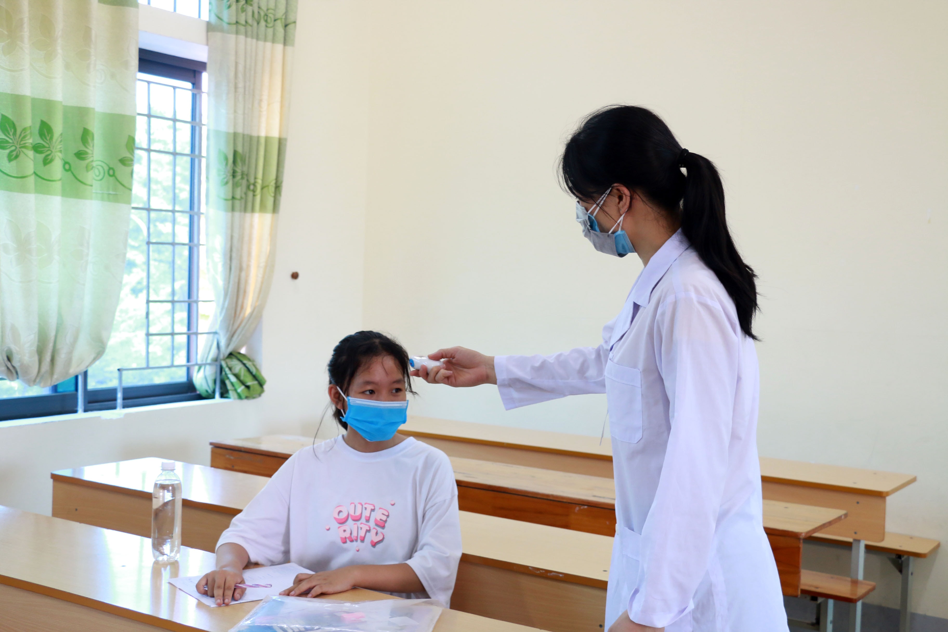 Trong ngày hôm nay, Ý đã được kiểm tra thân nhiệt nhiều lần. Tuy vậy, để đảm bảo an toàn, trước khi bắt đầu môn thi em được nhân viên y tế đo thêm một lần thân nhiệt. Ảnh: Mỹ Hà