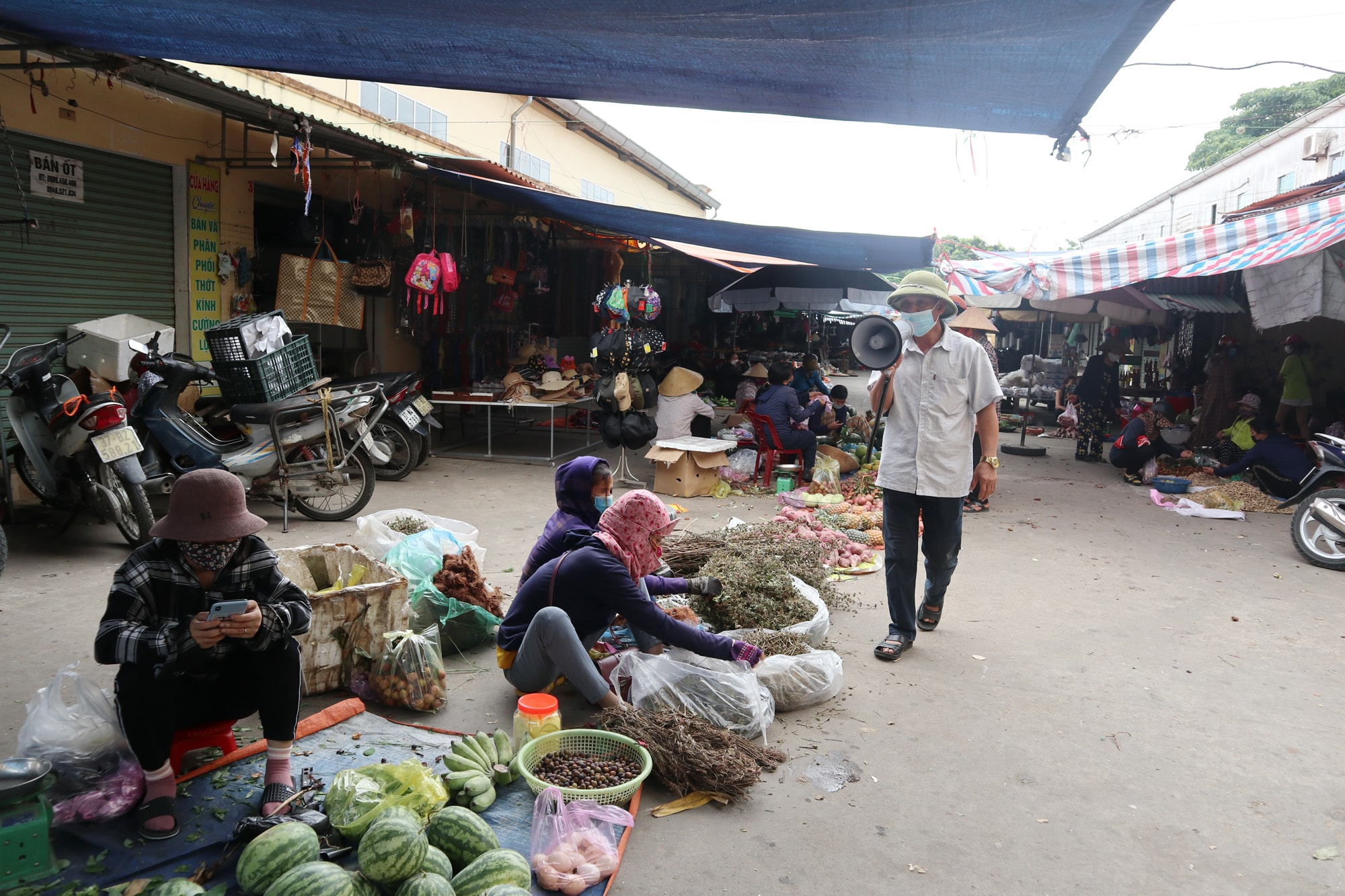 BQL chợ Cọi tuyên truyền các biện pháp phòng dịch qua hệ thống loa cầm tay. Ông Uông Văn Sỹ, Phó BQL chợ Cọi (xã Hưng Lộc, TP.Vinh) cho biết: “Khi có tin TP.Vinh có 11F1 và tại địa bàn xã có 2 F1 liên quan đến ca bệnh dương tính ở Hà Tĩnh, BQL chợ tăng cường, thắt chặt việc phòng dịch bằng nhiều biện pháp: Lập chốt gác cổng, kiên quyết không đeo khẩu trang thì không vào chợ, trực tiếp tuyên truyền, nhắc nhở người dân các biện pháp phòng dịch”. Ảnh: Thanh Phúc