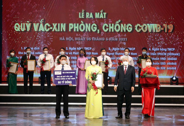 Đại diện Tập đoàn Masan nhận hoa và chứng nhận do các đồng chí lãnh đạo Đảng, Nhà nước trao tặng sau khi đóng góp 60 tỷ đồng vào Quỹ vaccine phòng chống dịch Covid-19.