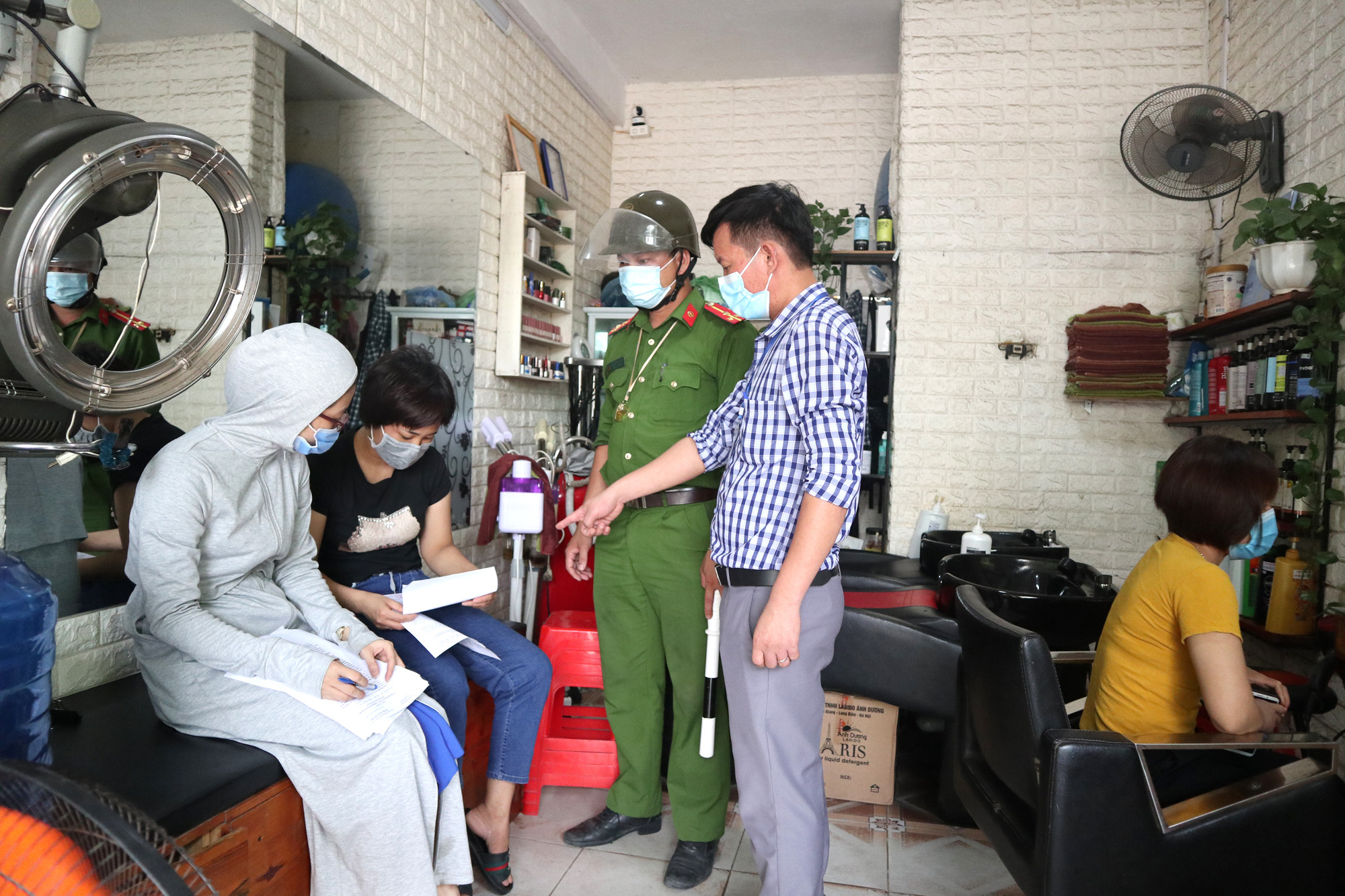 BCĐ phòng chống dịch Covid 19 xã Hưng Lộc (TP.Vinh) ký cam kết với cơ sở cắt tóc, gội đầu về việc tạm dừng hoạt động kinh doanh. Ảnh: Thanh Phúc