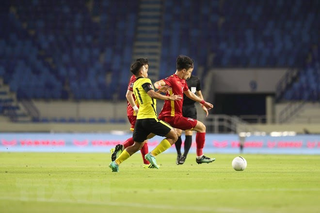 Pha đi bóng của Nguyễn Hoàng Đức (áo đỏ) ở trận đấu với Đội tuyển Malaysia. Ảnh: Hoàng Linh 