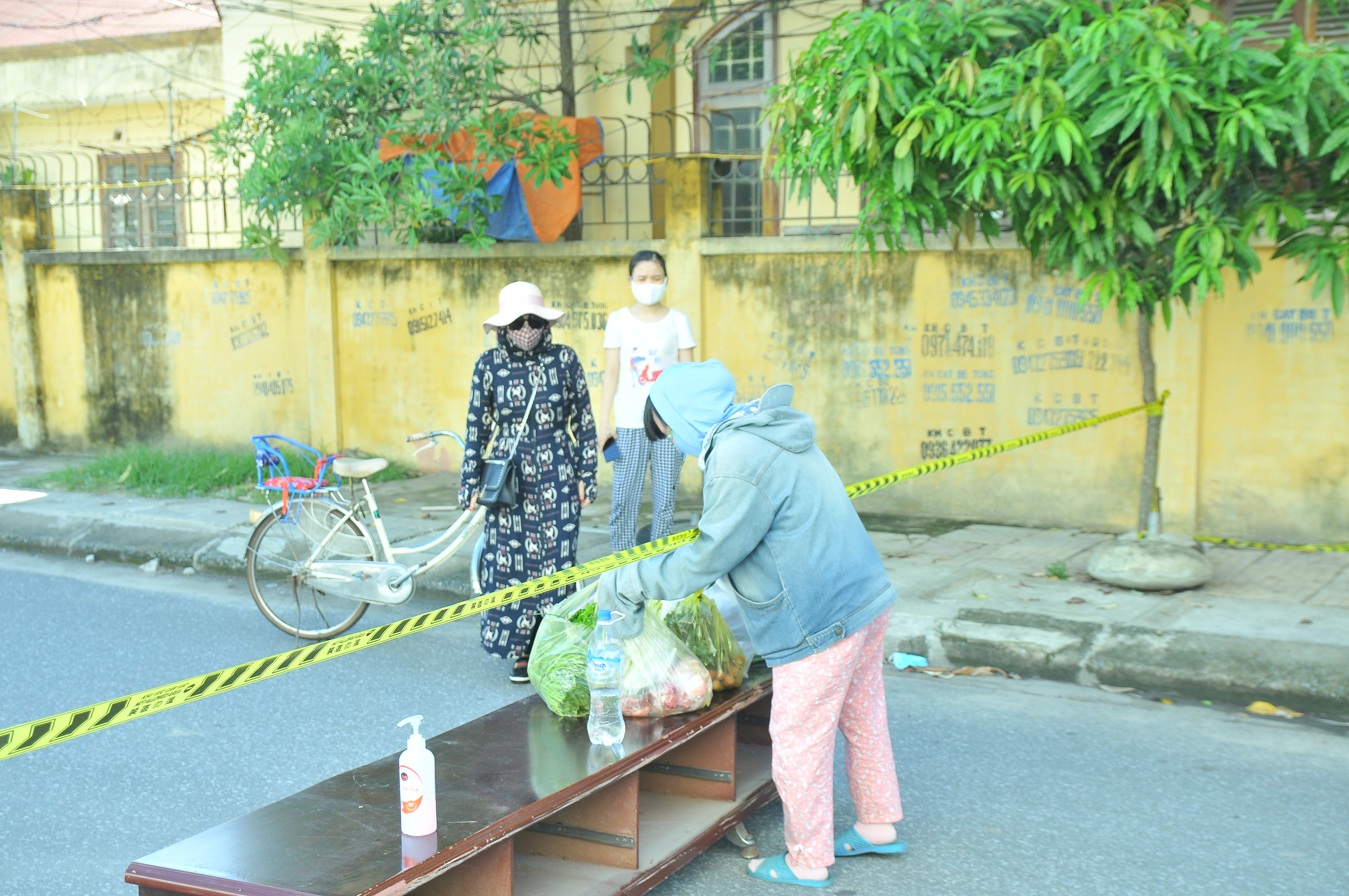 Người dân được hướng dẫn để đồ tiếp tế lên bàn sau đó người nhà sẽ đến lấy. Ảnh: Tiến Đông