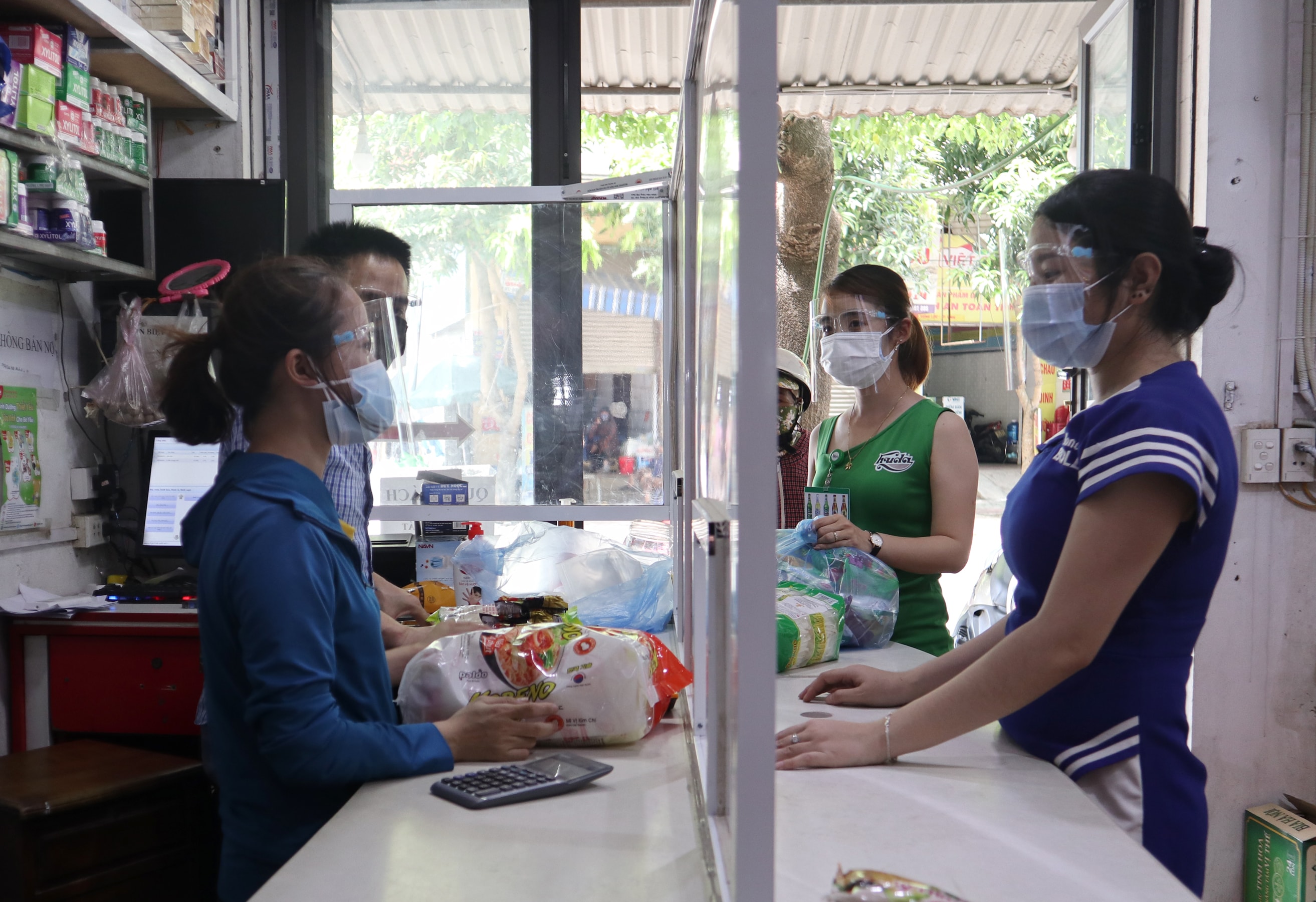 Khách hàng và nhân viên tại một cửa hàng ở thành phố Vinh đều trang bị kính chống giọt bán khi mua bán. Ảnh: Thanh Phúc