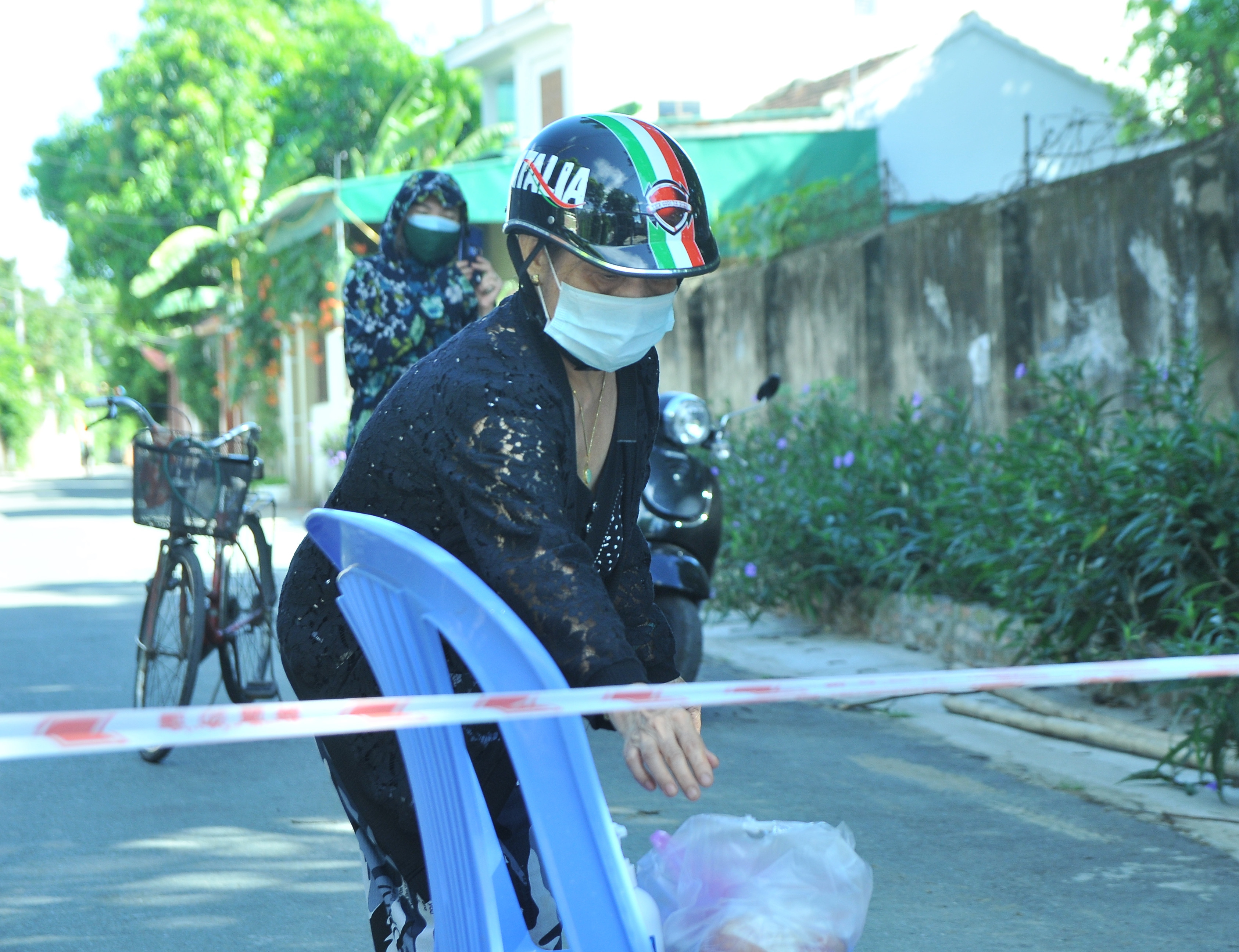 Do không có sự chuẩn bị nên nhiều người bên trong khu vực phong tỏa phải nhờ người thân mang thực phẩm đến tiếp tế. Ảnh: Tiến Đông