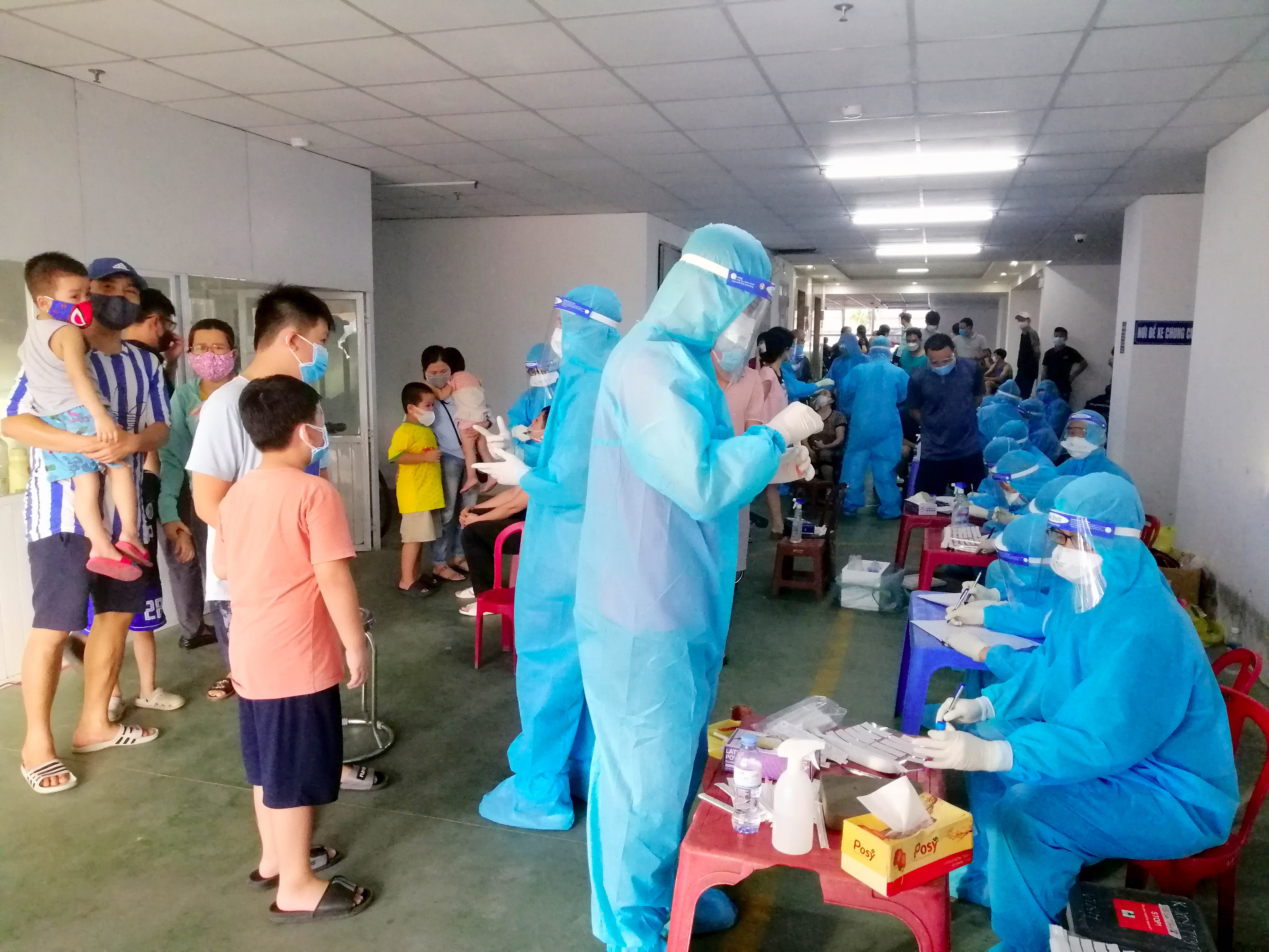 Đến khoảng 17 giờ, các cán bộ y tế của CDC Nghệ An đã có mặt tại khu B chung cư để tiến hành công tác lấy mẫu. Các hộ dân cũng đã tập hợp đầy đủ. Ảnh: Quang An