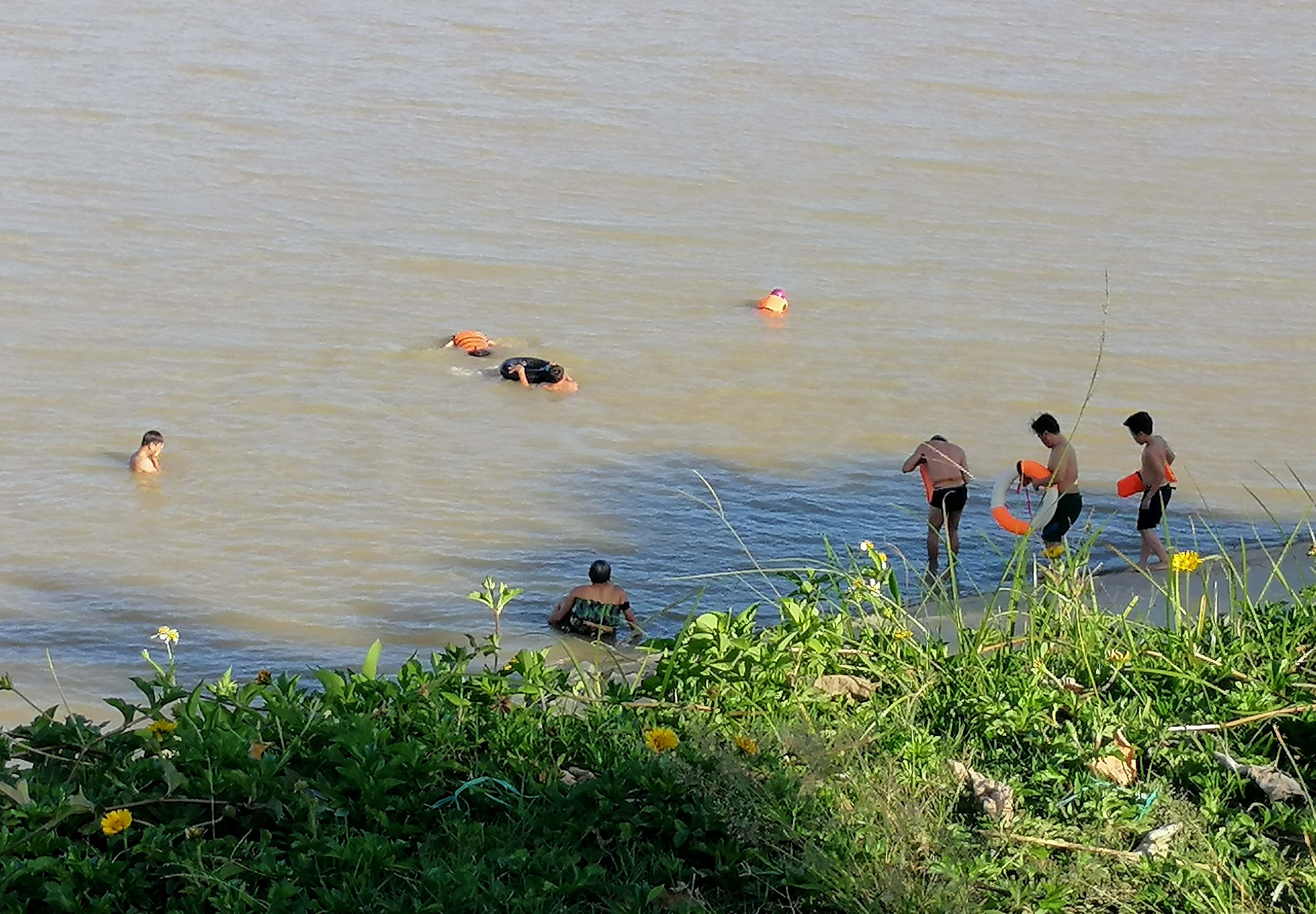 Nhiều người tụ tập tắm sông Lam trong chiều 21/6 giữa thời điểm thành phố đang cách ly xã hội. Ảnh: Q.A