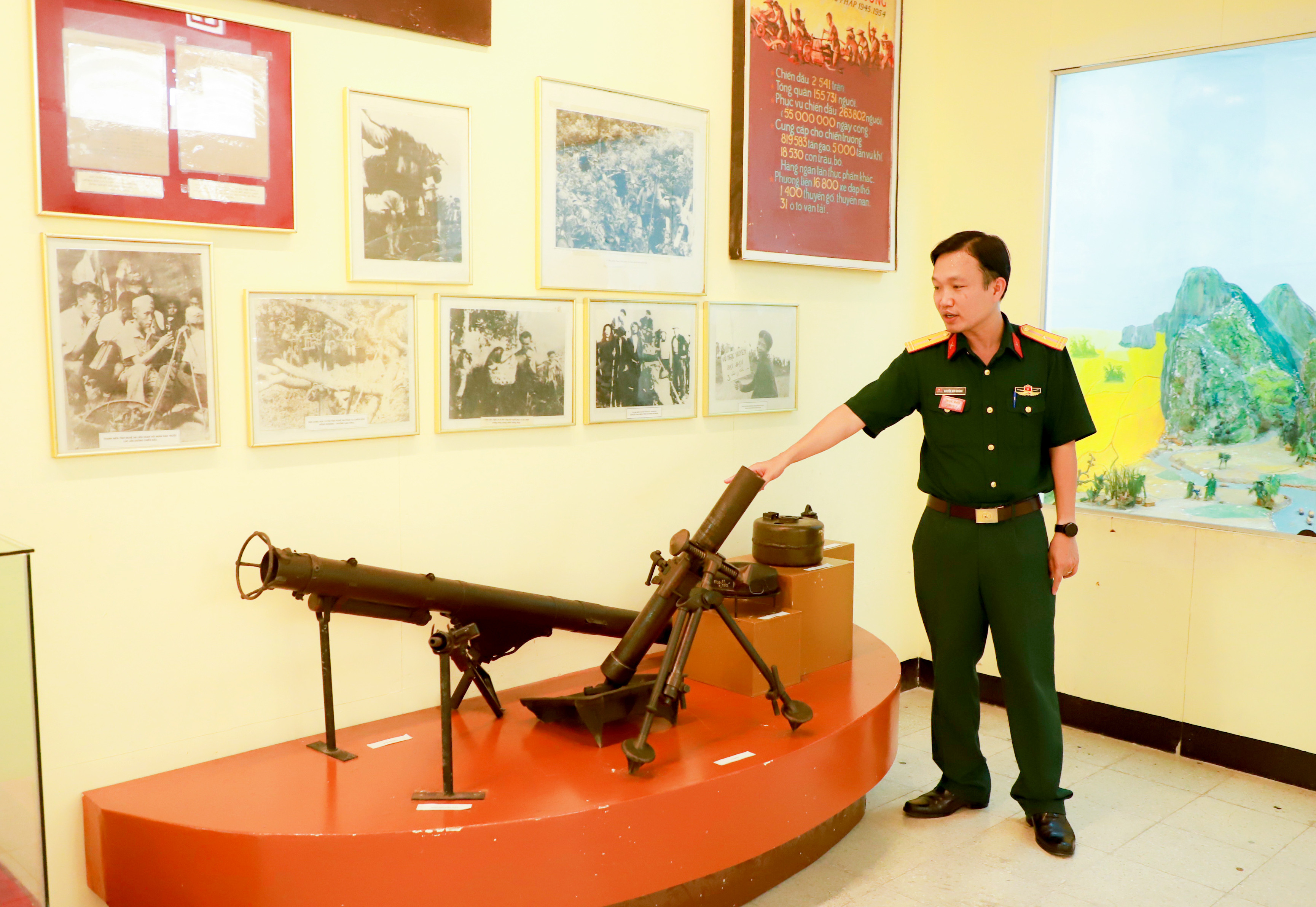 Thiếu tá Nguyễn Hữu Hoành - cán bộ Bảo tàng Quân khu 4 giới thiệu về các loại vũ khí trong kháng chiến chống Pháp được chế tạo từ nguyên liệu lò gang Như Xuân. Ảnh T.D