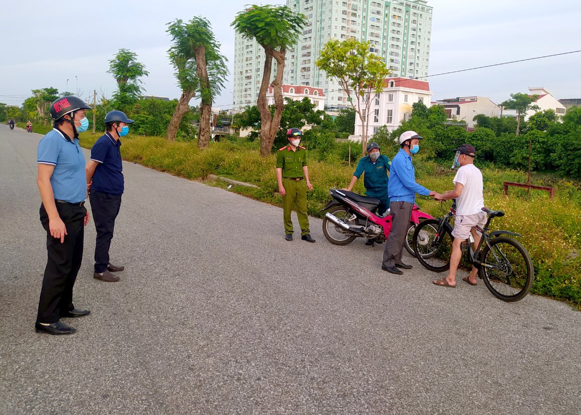 Lực lượng chức năng phường Cửa Nam xử lý các trường hợp ra ngoài không cần thiết trong mùa dịch. Ảnh: Q.A