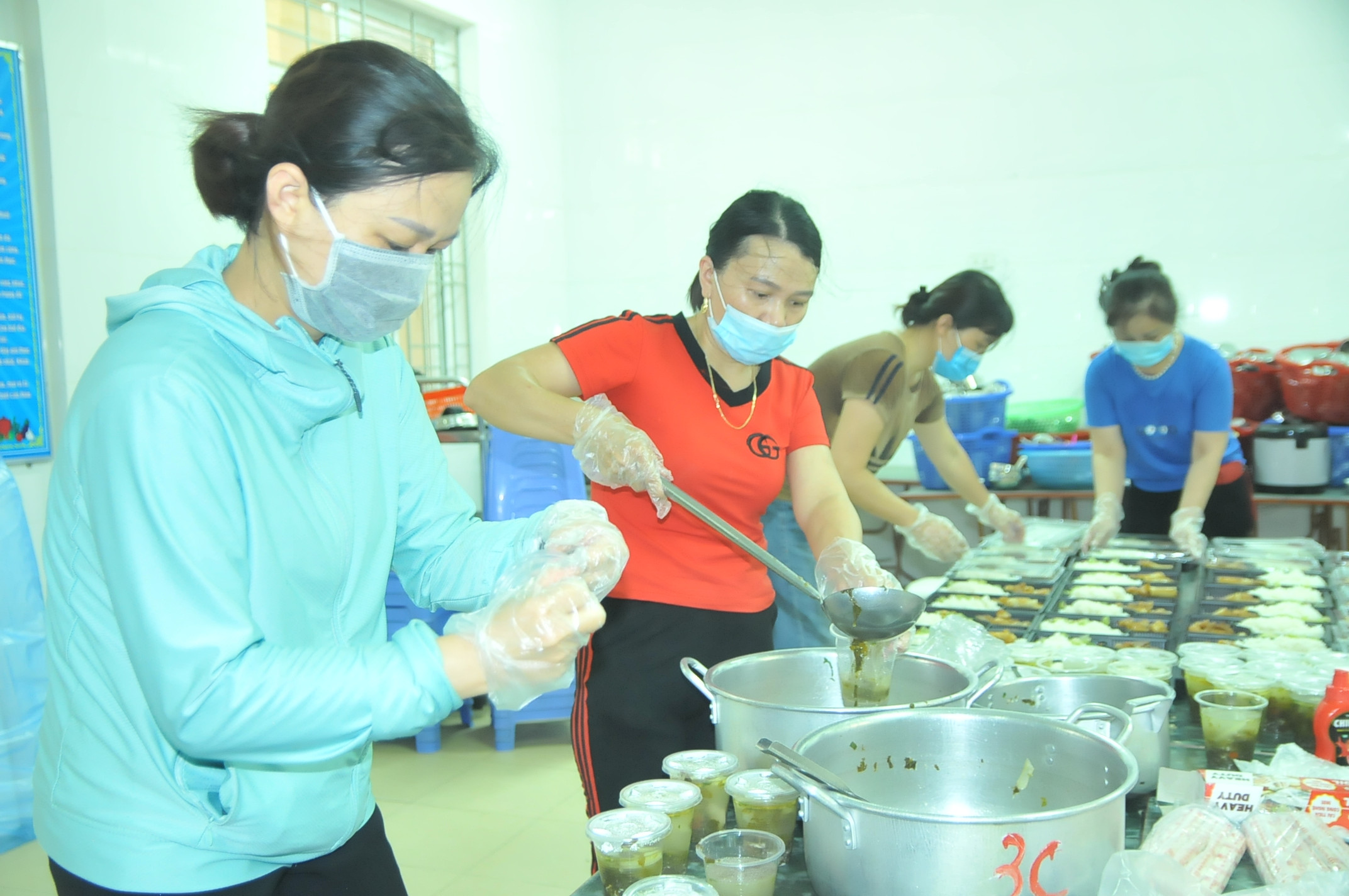 Các giáo viên Trường Tiểu học Nghi Ân chuẩn bị bữa cơm để mang đến cho các lực lượng đang làm nhiệm vụ tại chốt kiểm soát. Ảnh: Tiến Đông