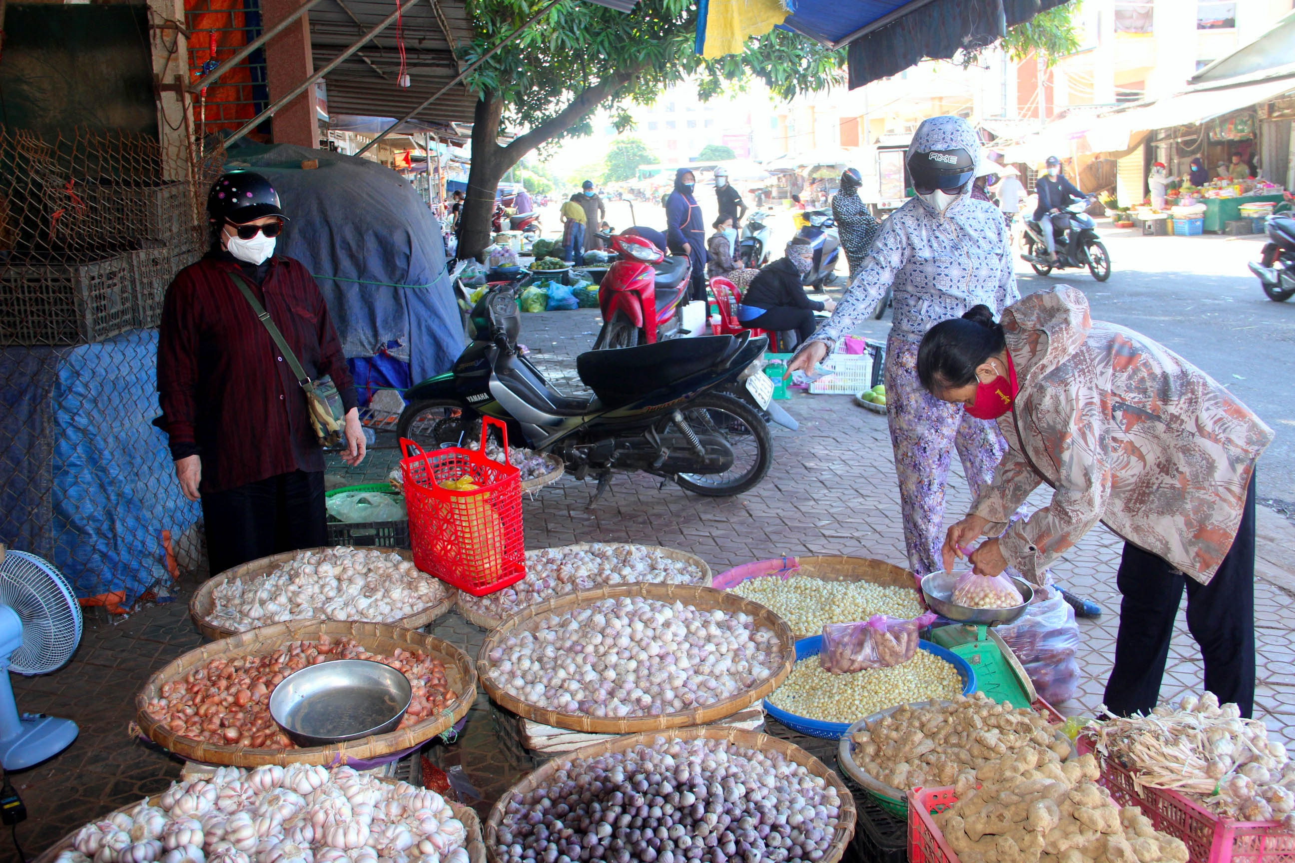 Tiểu thương và người dân mua bán tại khu vực đình Tây chợ Vinh đều thực hiện tốt việc đeo khẩu trang khi mua bán trong sáng 4/7. Ảnh: Quang An