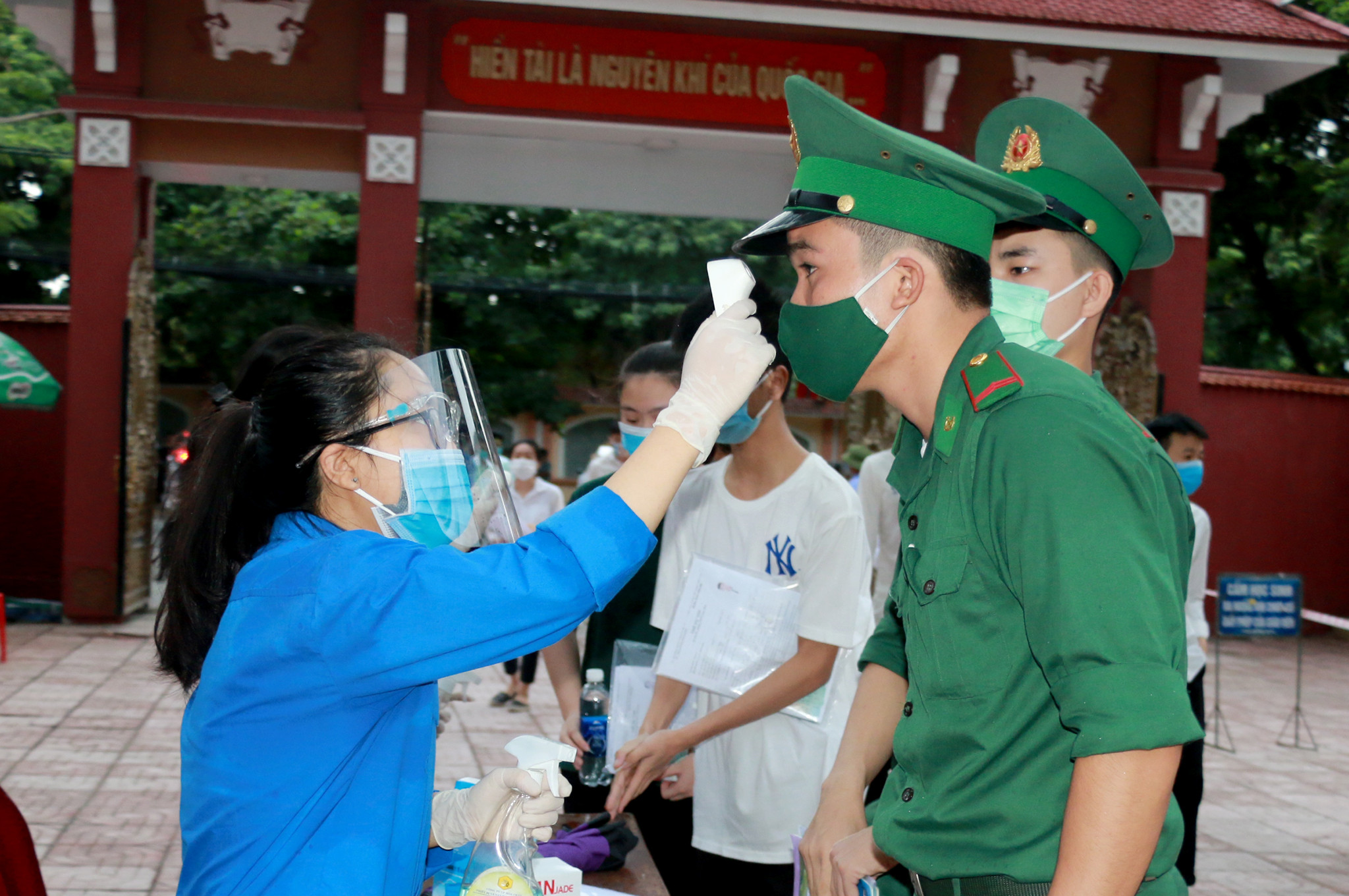 Đo thân nhiệt cho các thí sinh trước khi vào phòng thi. Ảnh: Đức Anh