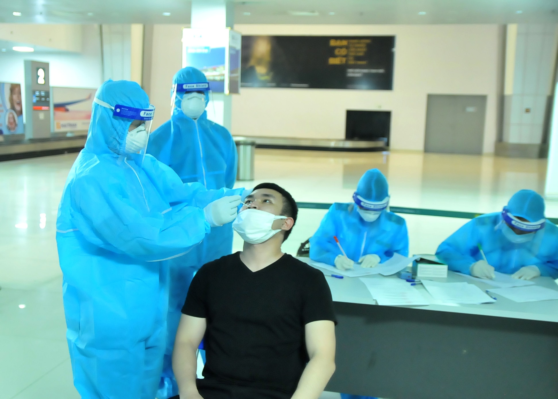 Cán bộ của CDC Nghệ An lấy mẫu test nhanh cho hành khách. Ảnh: Tiến Đông