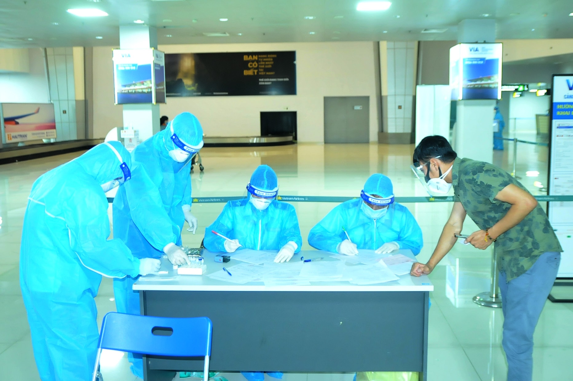 Hành khách khai báo thông tin tại bàn lấy mẫu. Ảnh: Tiến Đông