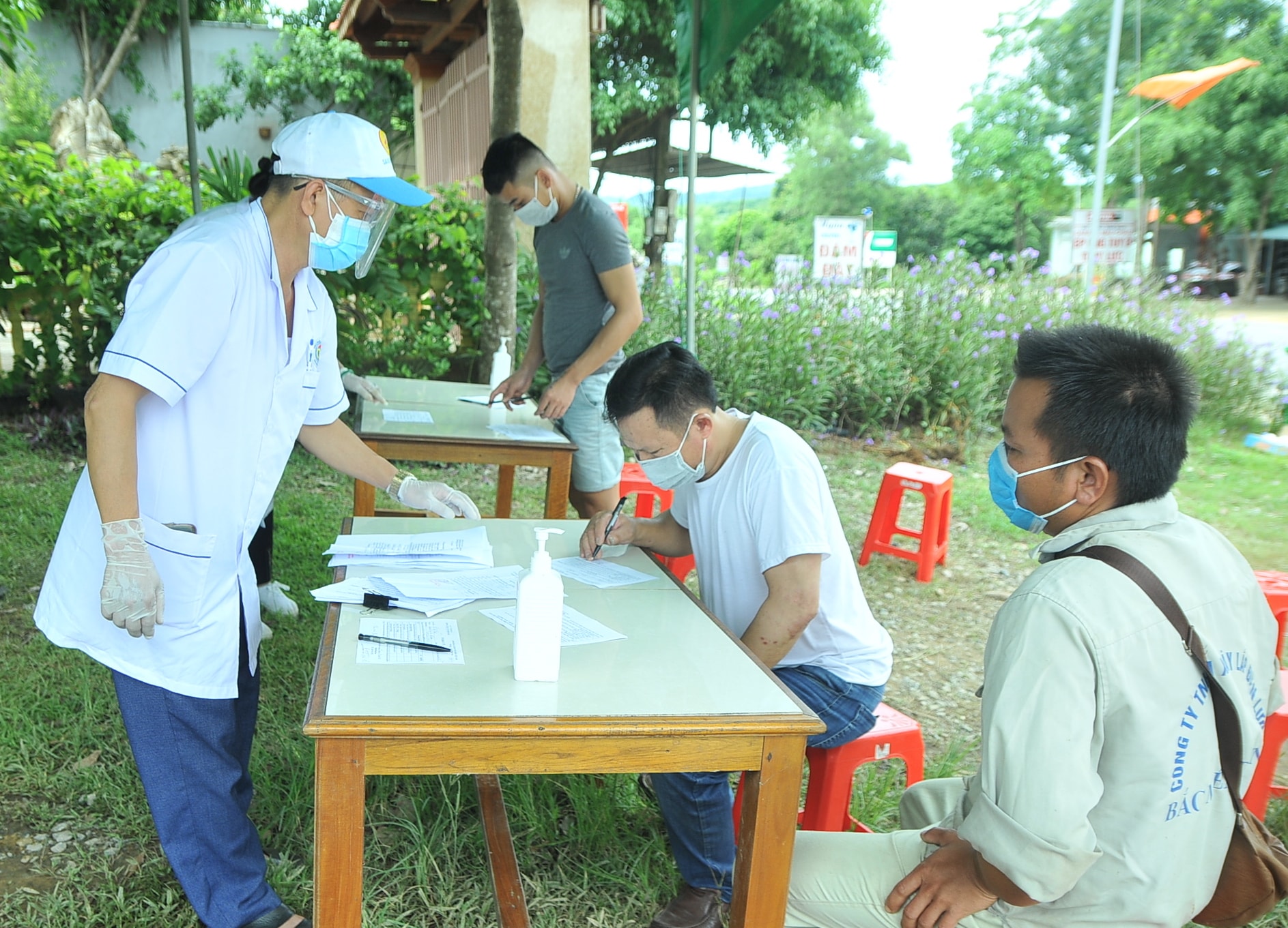 Cán bộ y tế tại chốt kiểm soát trên đường Hồ Chí Minh đoạn giáp ranh giữa Thanh Hóa và Nghệ An lấy thông tin khai báo của những người đi từ các tỉnh phía Bắc vào. Ảnh: Tiến Đông