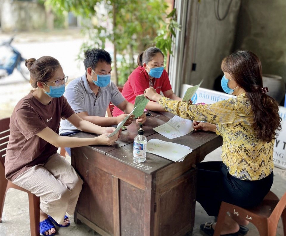 người dân tham gia BHXH tự nguyện nhận và đối chiếu thông tin trên sổ BHXH tại đại lý thu BHXH, BHYT phường Hưng Dũng, thành phố Vinh. Ảnh BHXH tỉnh