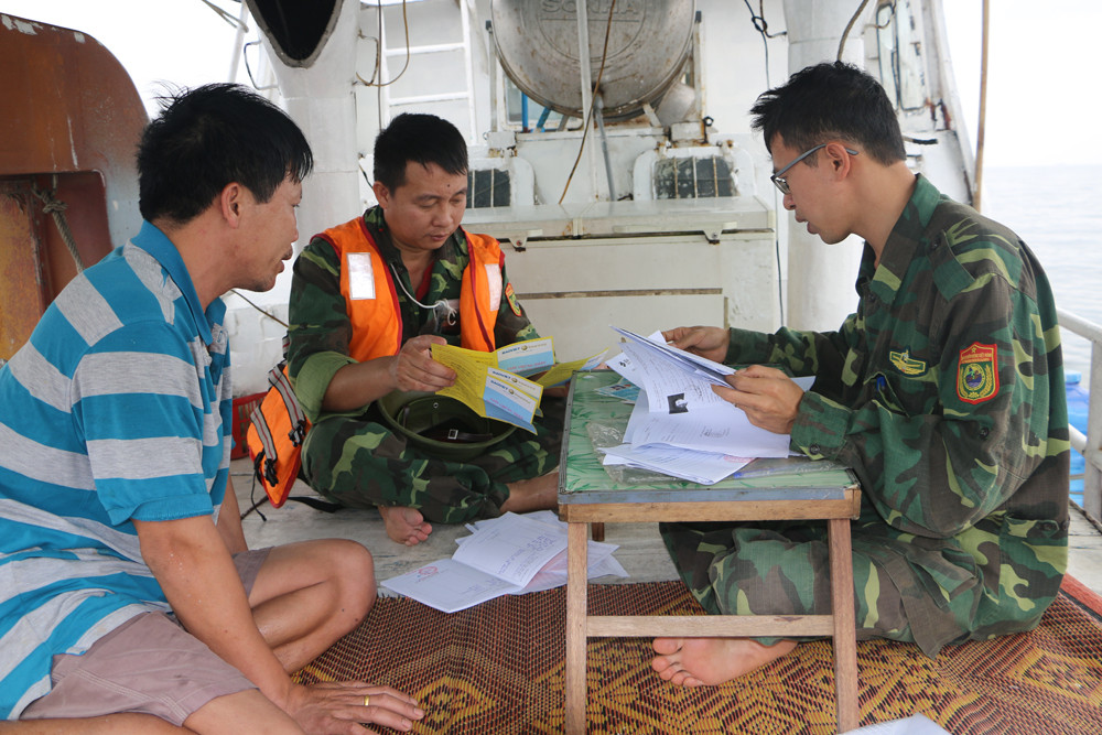 Tuyên truyền, kiểm tra giấy tờ chủ tàu cá trước khi lập biên bản xử phạt. Ảnh: Nguyễn Hải