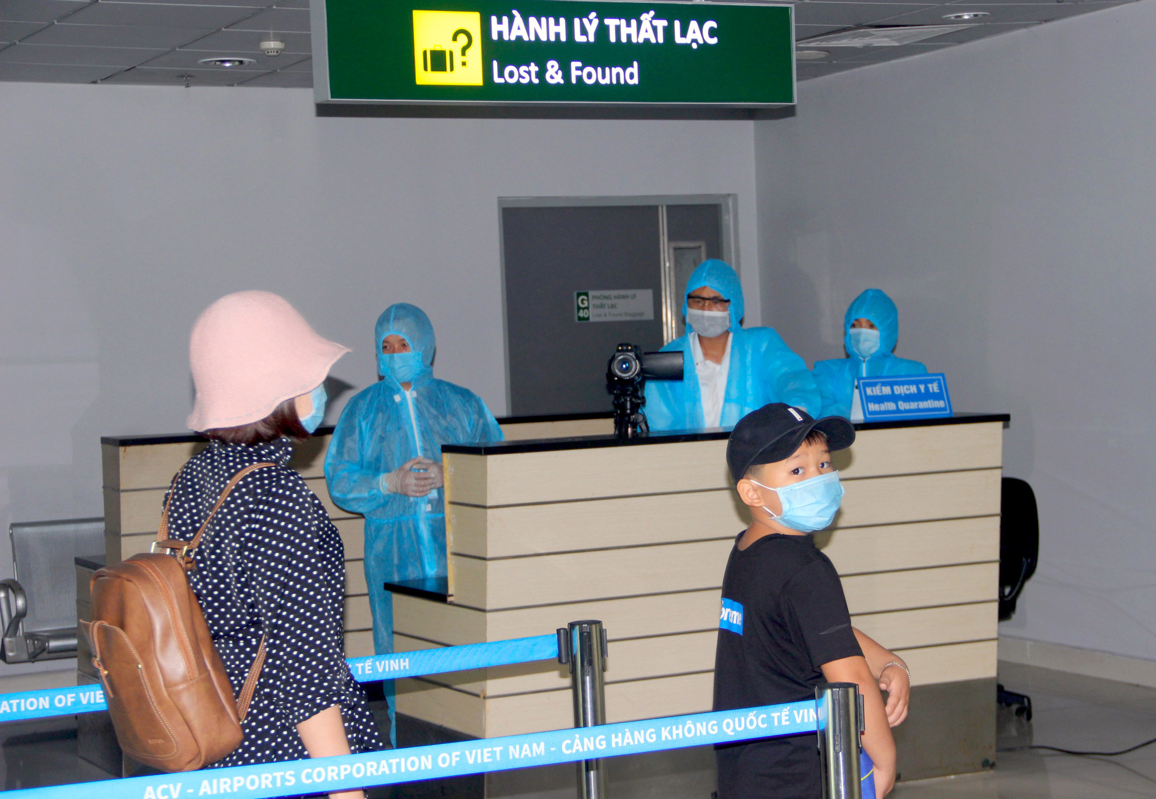 Nhân viên y tế của CDC Nghệ An đo thân nhiệt từ xa đối với hành khách xuống sân bay Vinh. Ảnh: Quang An