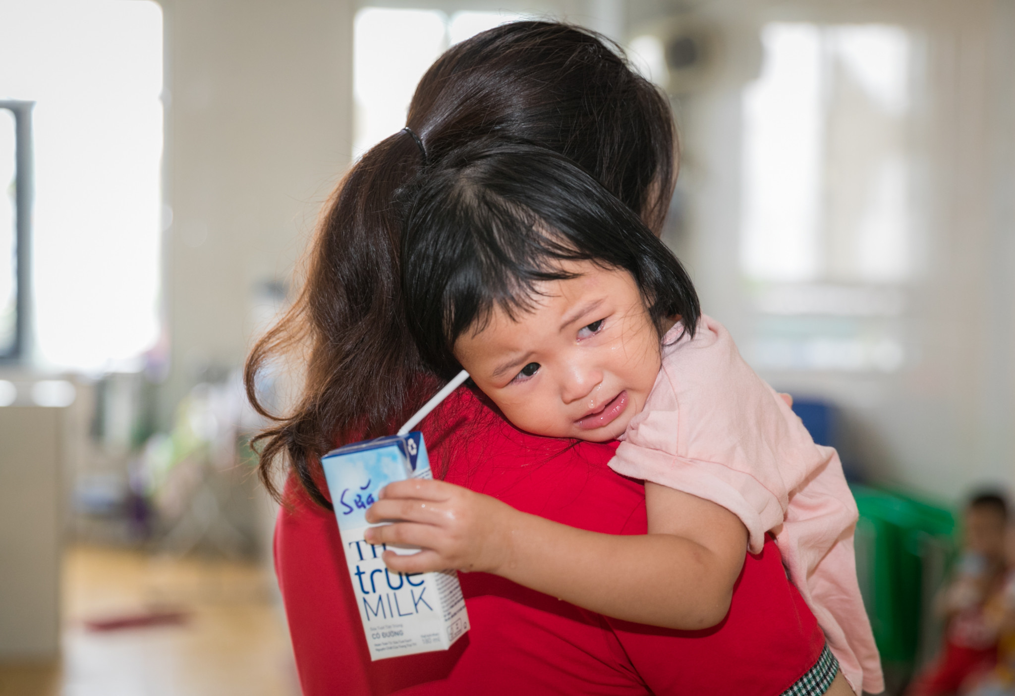 Nhiều bé còn bỡ ngỡ trong ngày trở lại trường, cô giáo phải dỗ giành các bé mới nín khóc. Ảnh: Đức Anh