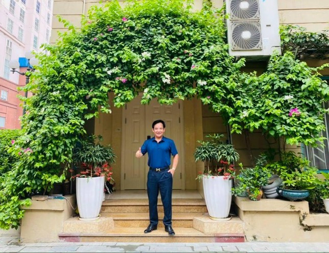 Quang Tèo đứng trước cửa nhà rợp cây xanh