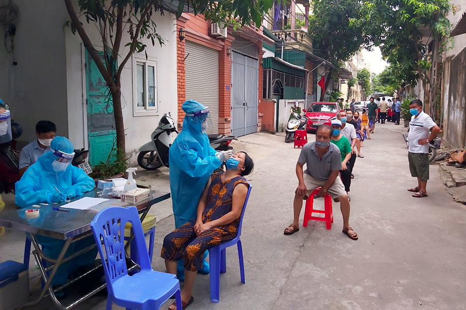 Nhân viên y tế tiến hành lấy mẫu người dân trong khu vực phong tỏa tại khối 6 phường Cửa Nam. Ảnh: Q.A
