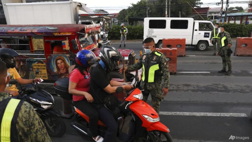 Cảnh sát kiểm tra người điều khiển mô tô tại trạm kiểm soát ở thành phố Marikina, Philippines hôm 6/8. Ảnh: AP