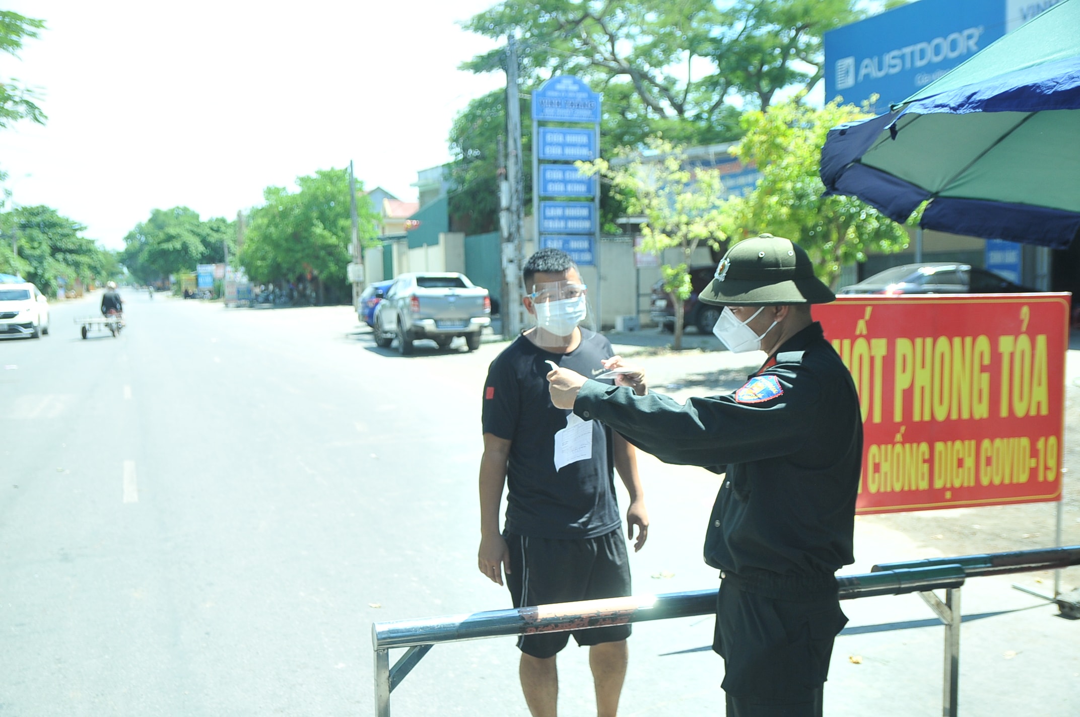 Người dân phải xuất trình được giấy xét nghiệm âm tính và các giấy tờ cần thiết (đối với phương tiện vận chuyển vật liệu xây dựng), thì mới được qua chốt. Ảnh: Tiến Đông