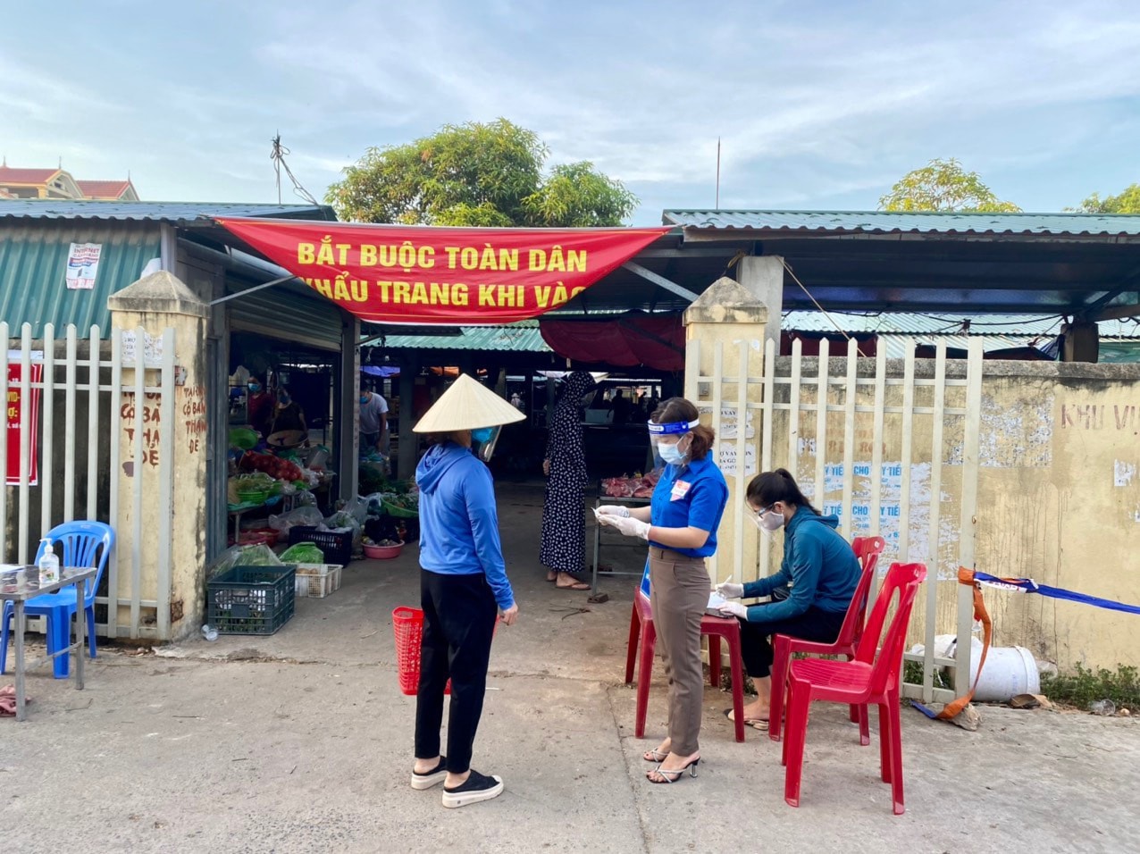 Trước khi vào chợ, người dân phải xuất trình phiếu và các giấy tờ tùy thân chứng minh. Ảnh: TĐ