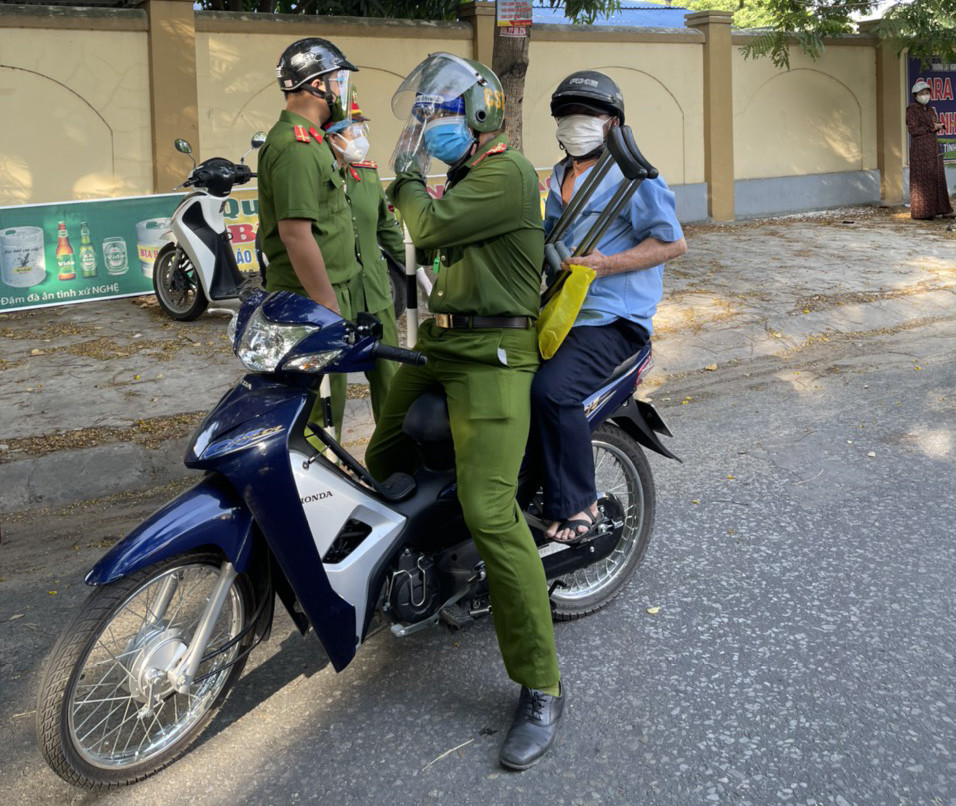 Đại úy Nguyễn Mạnh Cường dùng xe mô tô chở ông Thái Văn Dương về nhà. Ảnh: Đức Vũ