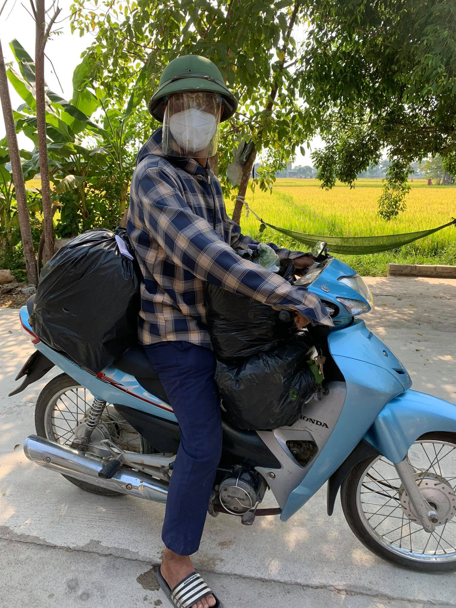 Một thành viên của tổ cung ứng hàng thiết yếu trên địa bàn xóm Phan Đăng Lưu, xã Nam Thành vận chuyển hàng đến tận nhà cho người dân. Ảnh: PV