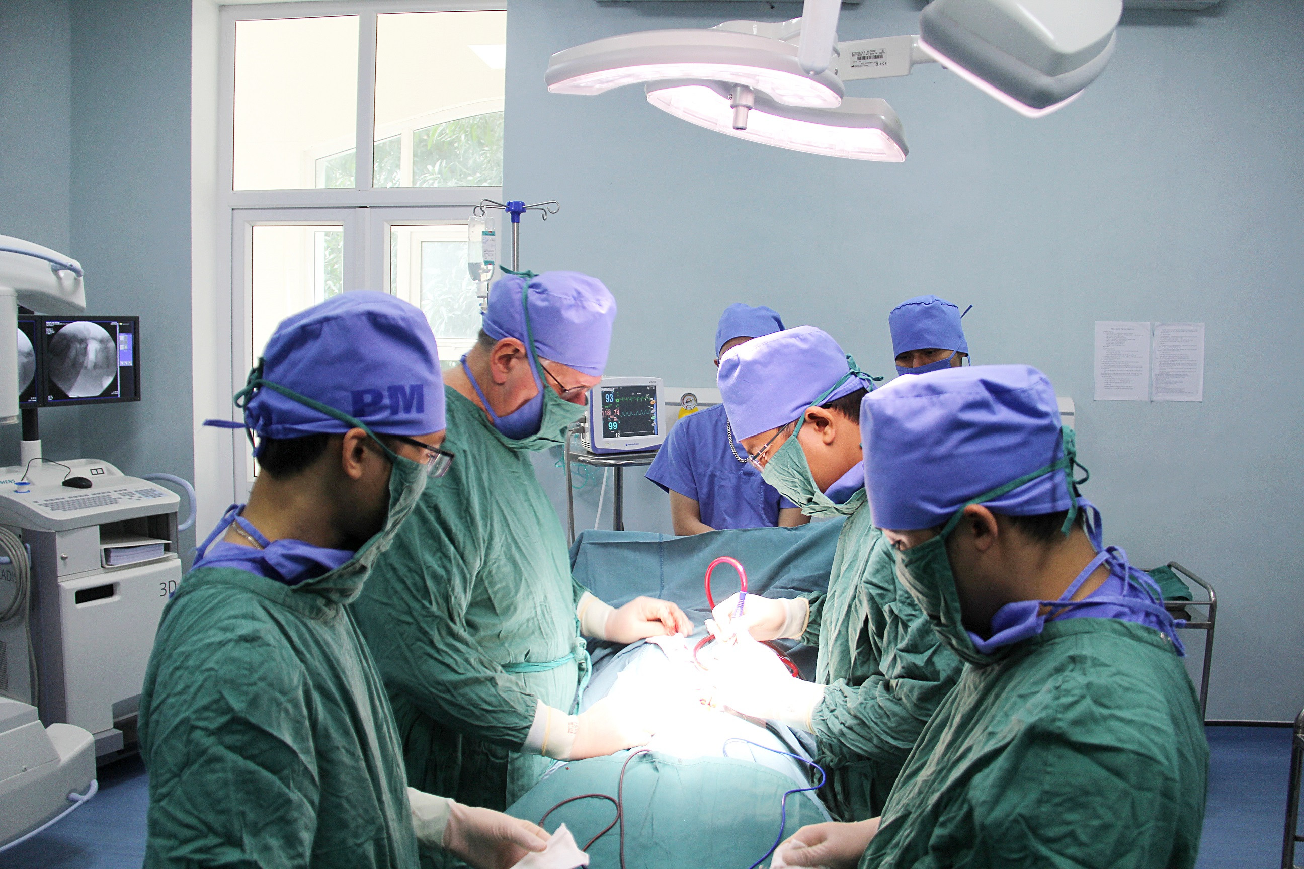 Bác sỹ Trần Văn Biên (giữa phải) thực hiện phẫu thuật cho bệnh nhân. Ảnh: Thanh Lê