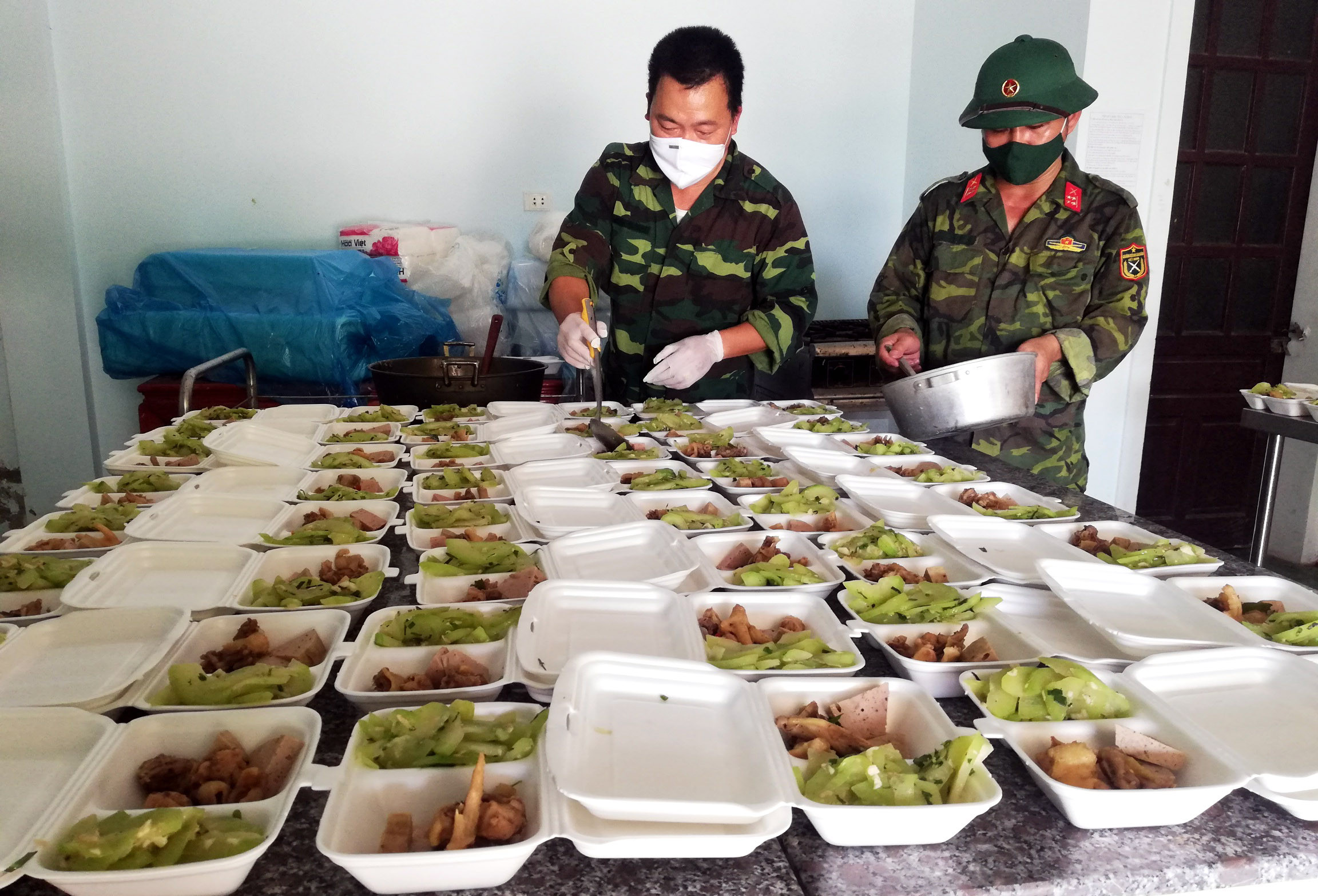 Các tình nguyện viên tham gia nấu ăn phục vụ tại khu cách ly tập trung huyện Diễn Châu. Ảnh Mai Giang