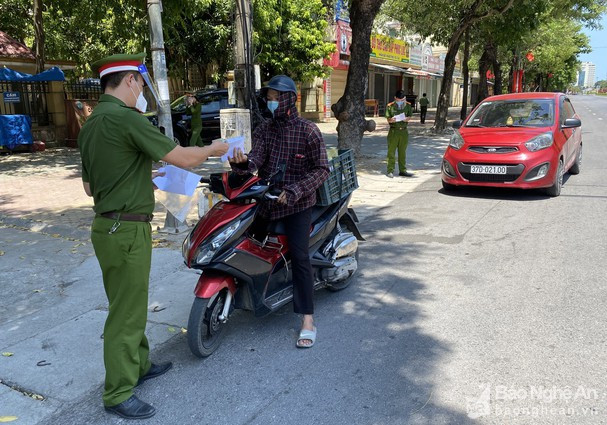 Lực lượng chức năng kiểm tra giấy tờ người dân khi đi qua các điểm chốt. Ảnh: Quang An