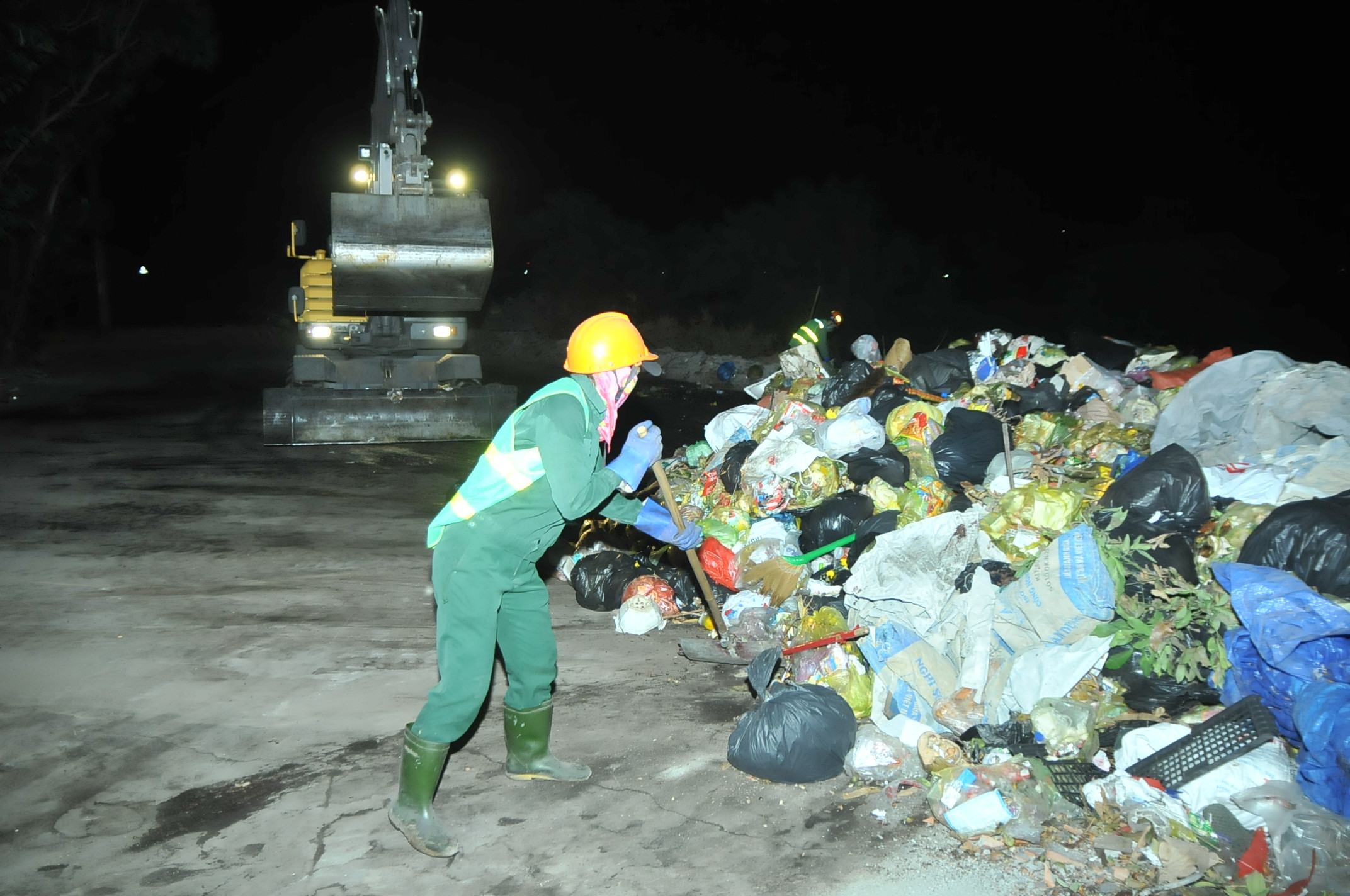 Sau khi quét và hốt hết rác trên tuyến đường được giao, chị Hoàn và chị Thảo lại phải gom rác về điểm tập kết để chờ xe tải đến bốc đi. Ảnh: Tiến Đông