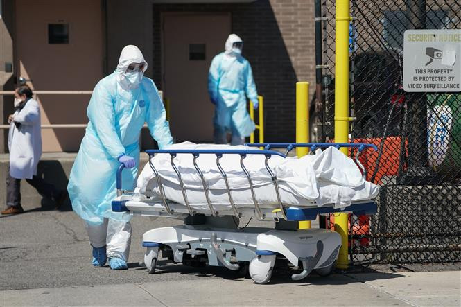 Nhân viên y tế chuyển thi thể bệnh nhân COVID-19 tại bệnh viện ở New York, Mỹ. Ảnh: AFP/ TTXVN