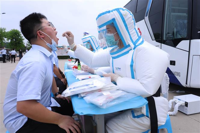Nhân viên y tế lấy mẫu xét nghiệm COVID-19 cho người dân tại tỉnh Hà Nam, Trung Quốc, ngày 19/8/2021. Ảnh: THX/ TTXVN