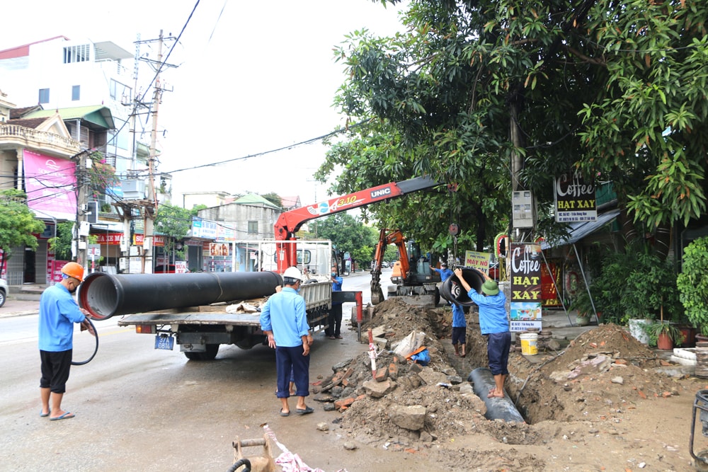 Công nhân Công ty CP cấp nước tranh thủ lắp đặt đường ống cấp nước cùng với thi công mương thoát dọc đường Trần Hưng Đạo về Trạm bơm hồ Cửa Nam - một trong những vùng ngập năng tại Cửa Nam. Ảnh: Nguyễn Hải