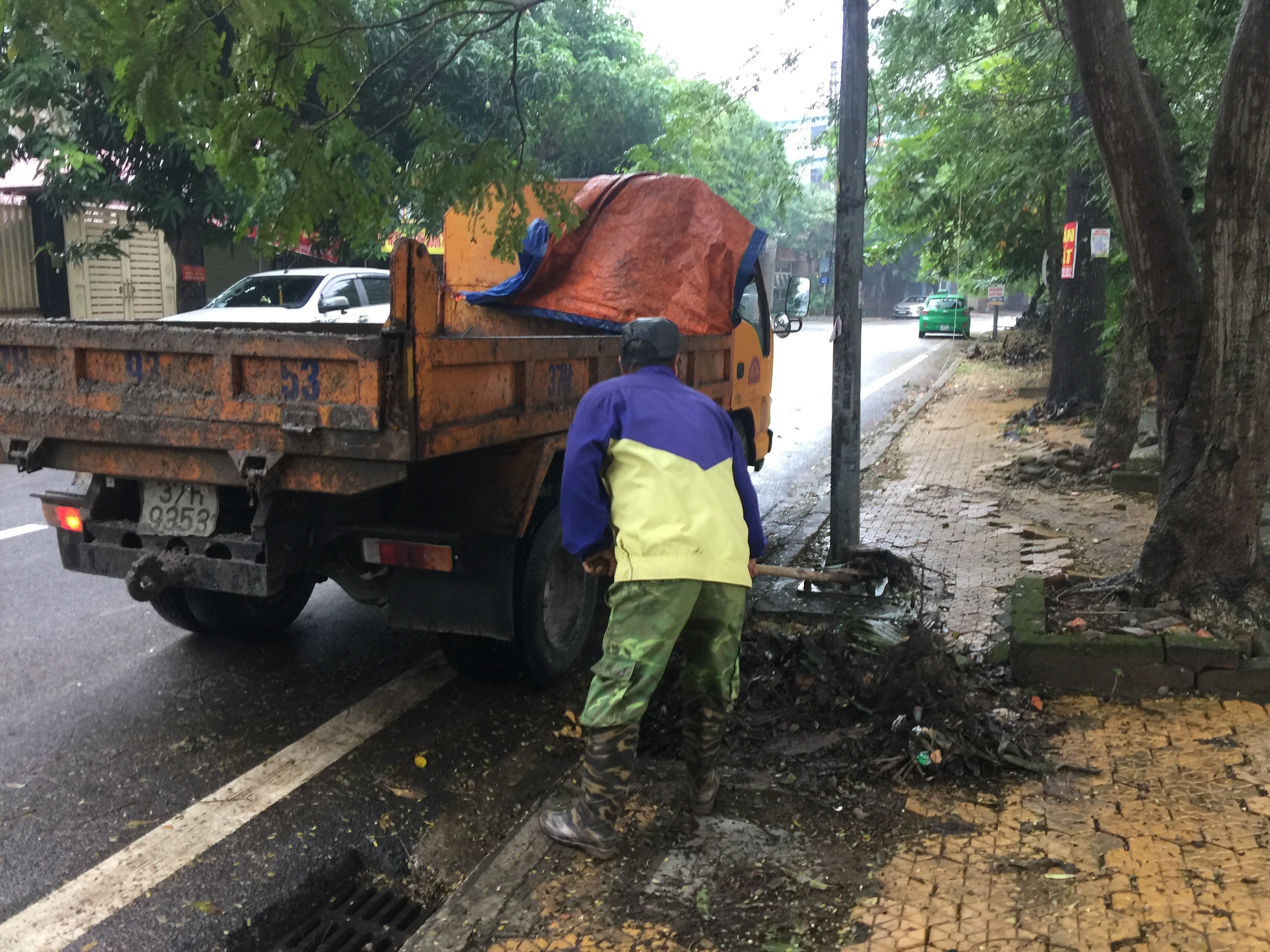 Công nhân Công ty CP Quản lý và phát triển Hạ tầng đô thị Vinh nạo vét mương thoát trên đường Duy Tân. Ảnh: Nguyễn Hải