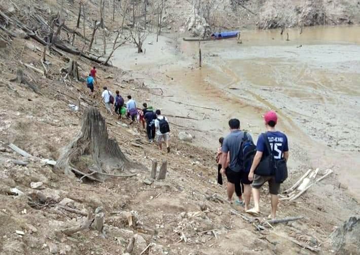 Sau khi vượt suối, họ còn phải men theo các lối mòn đi bộ chừng 2 km nữa mới có thể vào đến điểm trường dạy học. Ảnh: Đào Thọ