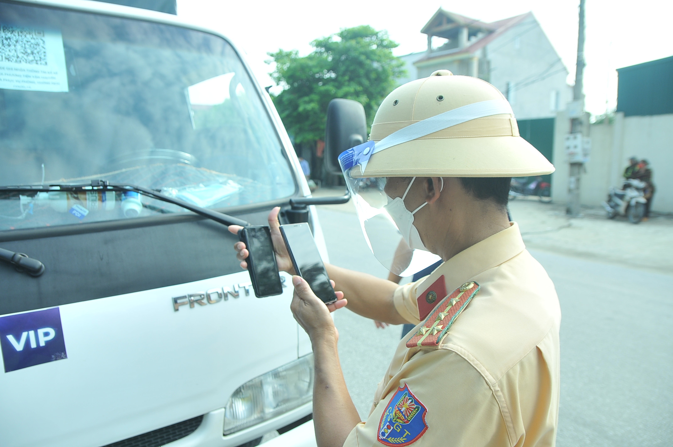 Đại  Nguyễn Văn Lâm, cán bộ Đội CSGT-TT, Công an TP.Vinh cho biết: Lượng người đổ xô qua chốt kiểm soát rất đông khiến cho lực lượng làm nhiệm vụ tại đây phải căng sức kiểm tra, thậm chí là phải giải thích cho người dân biết rõ những quy định về phòng dịch của thành phố. Trong ảnh, kiểm tra mã QR Code của xe tải chở hàng vào TP.Vinh tại chốt kiểm soát trên đường Lê Viết Thuật. Ảnh: Tiến Đông 