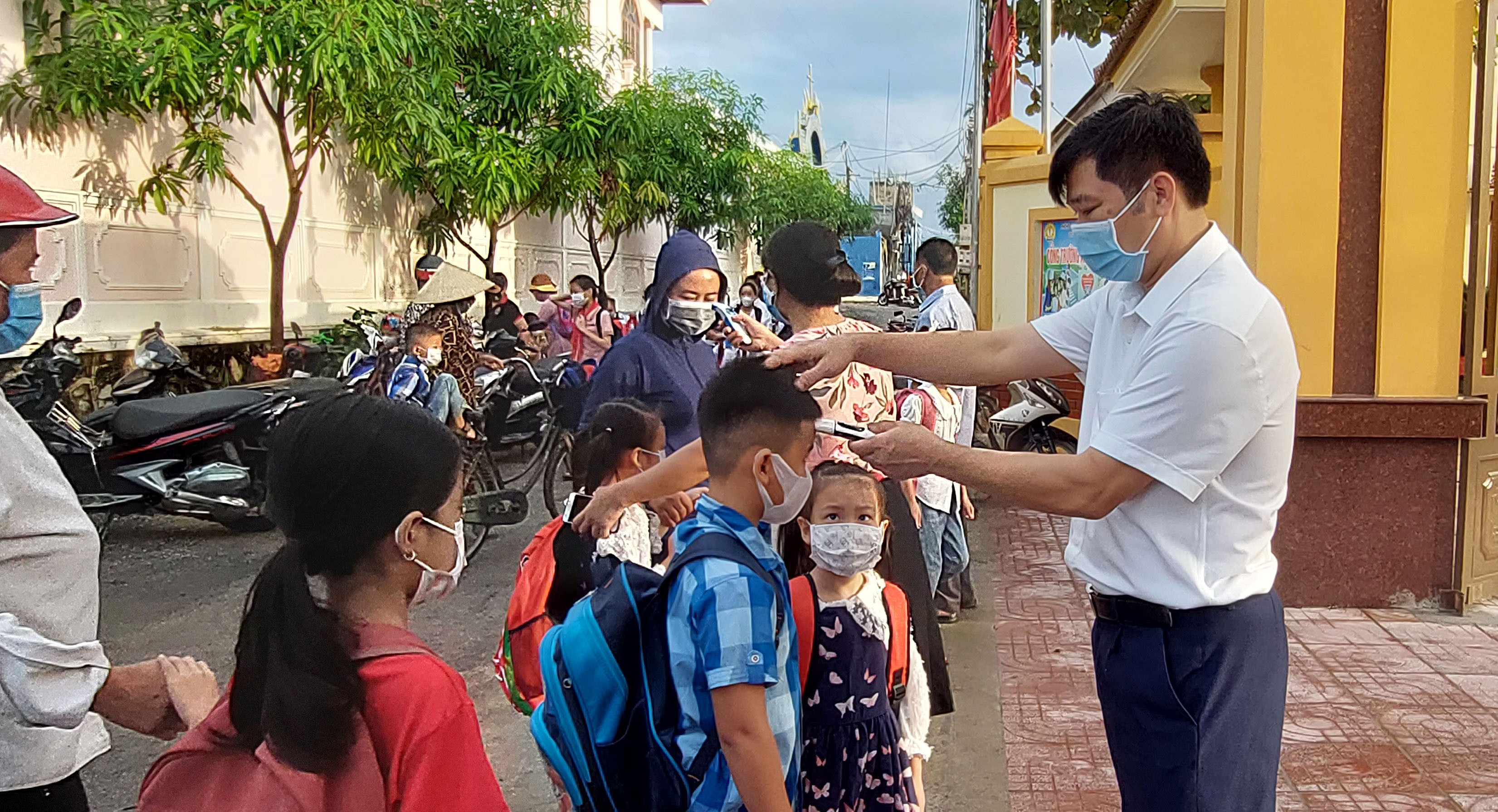 Trường Tiểu học Diễn Thịnh (Diễn Châu) kiểm tra thân nhiệt cho học sinh khi trở lại trường. Ảnh: Mai Giang
