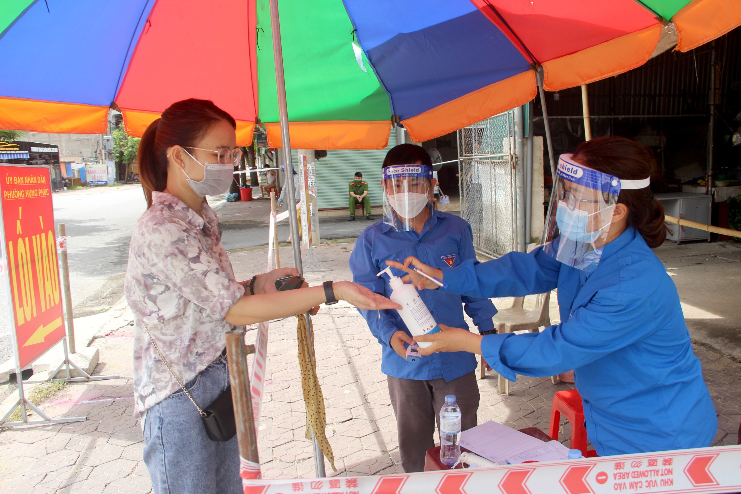 Người dân thực hiện các thủ tục y tế khi vào chợ. Ảnh: Quang An