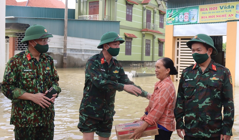 Đại tá Ngô Quốc Hải, Phó Chính ủy Bộ CHQS tỉnh tặng nhu yếu phẩm cho các gia đình bị ngập sâu và có hoàn cảnh khó khăn. Ảnh: Trọng Kiên