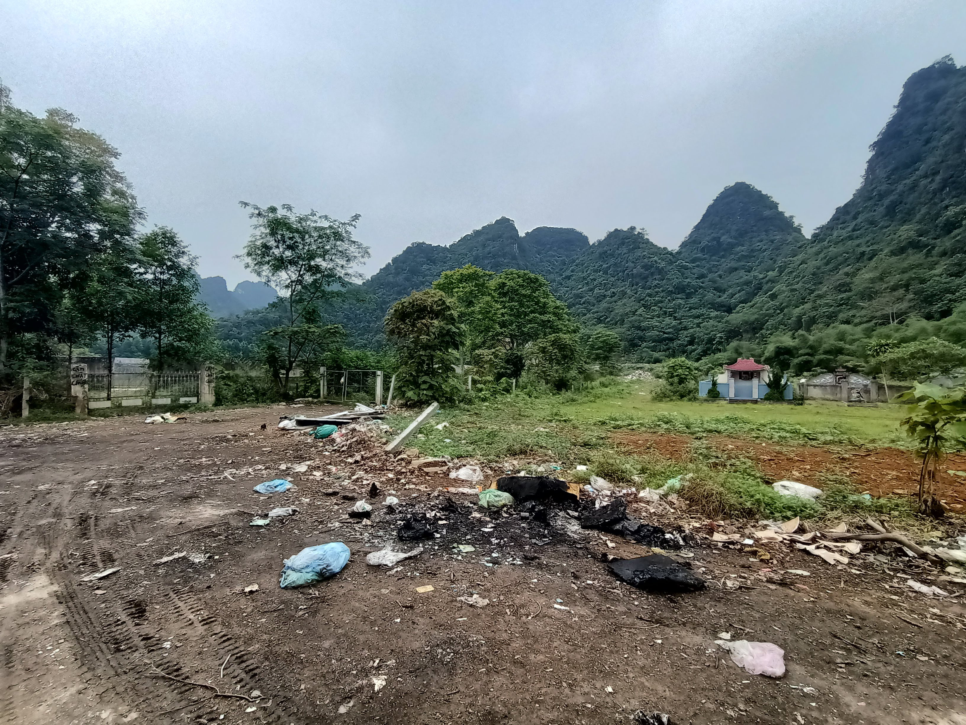 Lối vào bãi rác, hai bên là nghĩa trang và sân vận động của huyện Con Cuông. Ảnh: Tiến Đông 